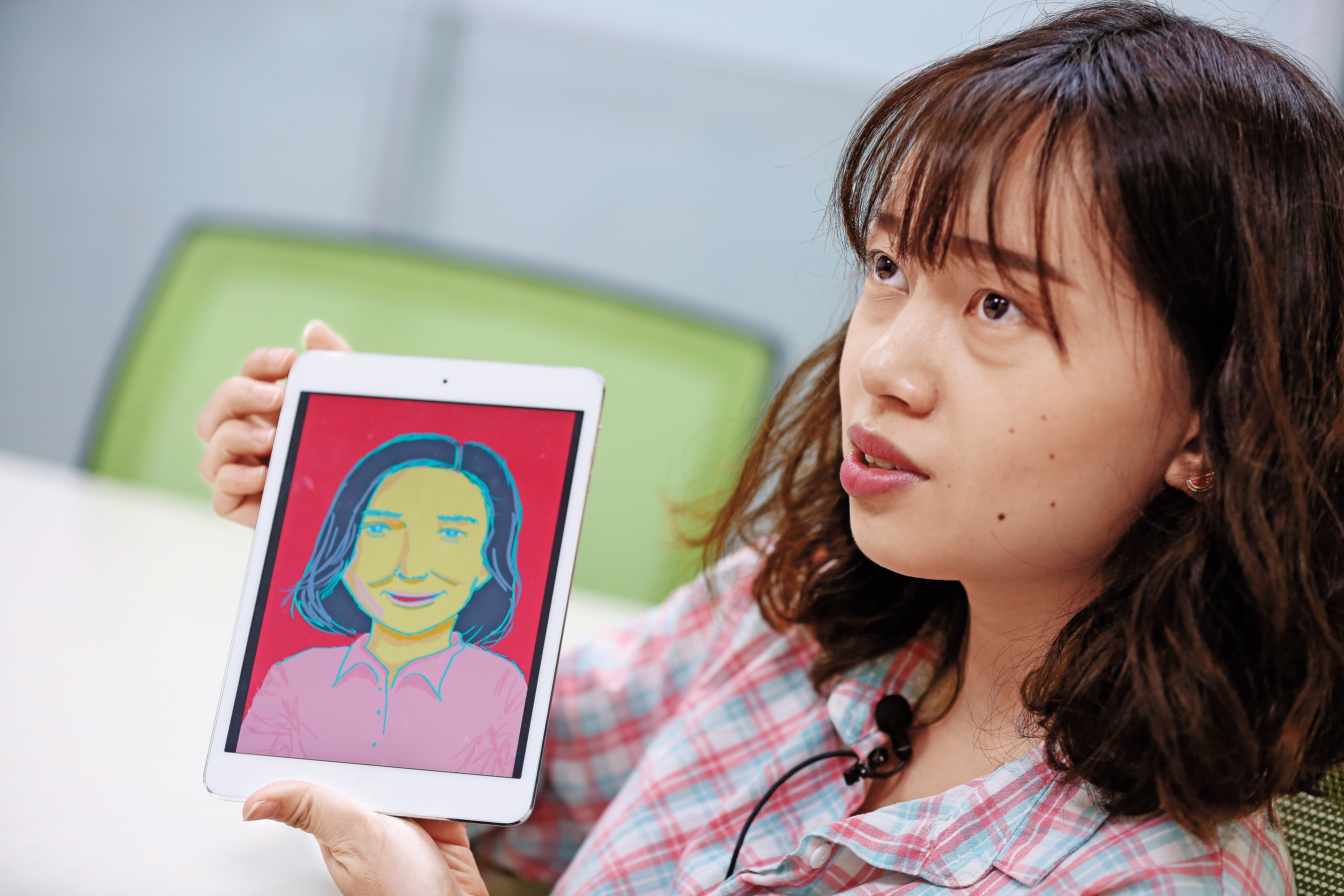 呱呱用平板滑著自己當時替蔡宜珊設計的作品，每一張圖都是純手工繪製。