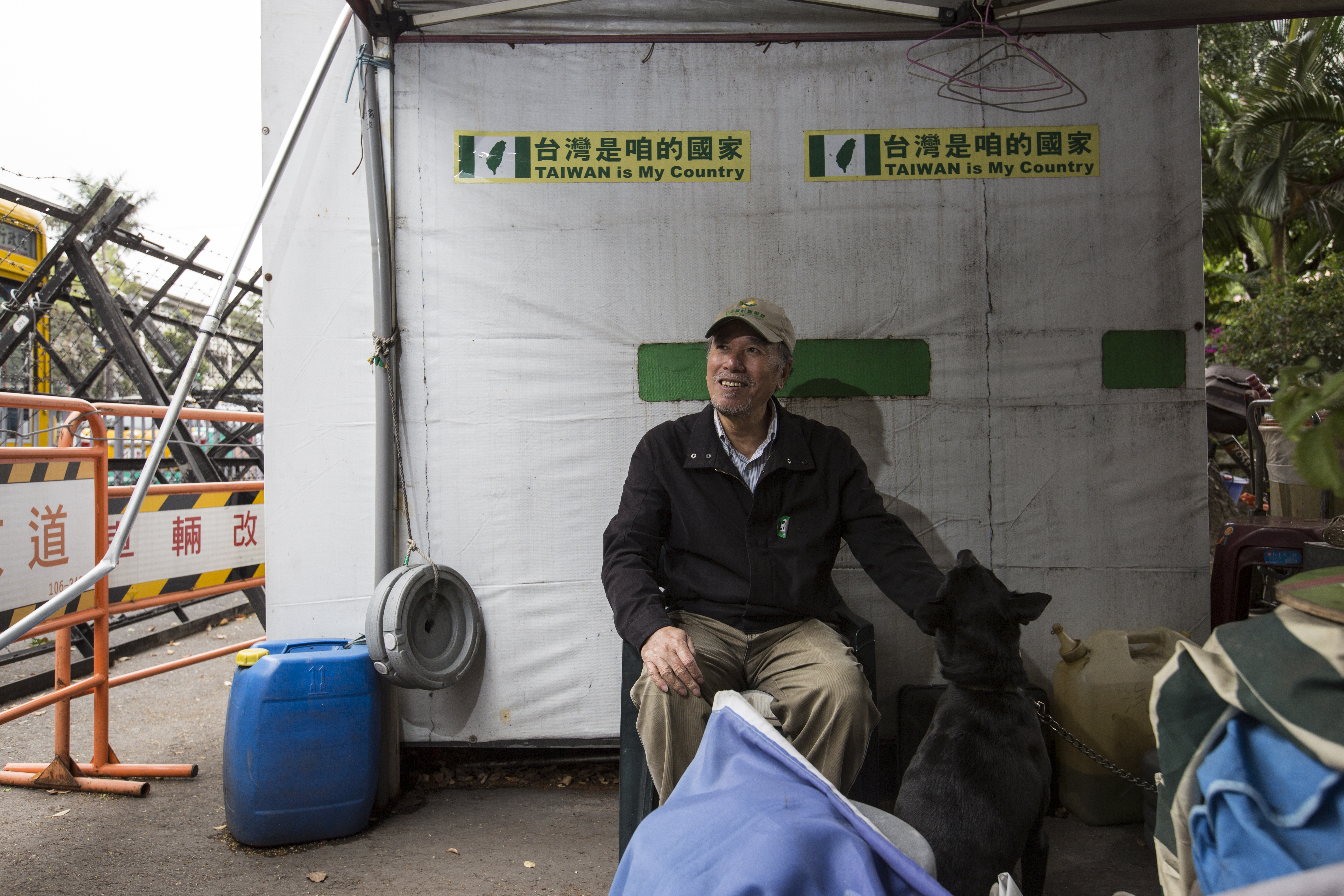 蔡丁貴的台獨帳棚在我們採訪後第三天被拆，圖中的小黑狗也跟著駐地超過8年，原本性情乖順，因被反對者毆打過，現在對陌生人有很大戒心。