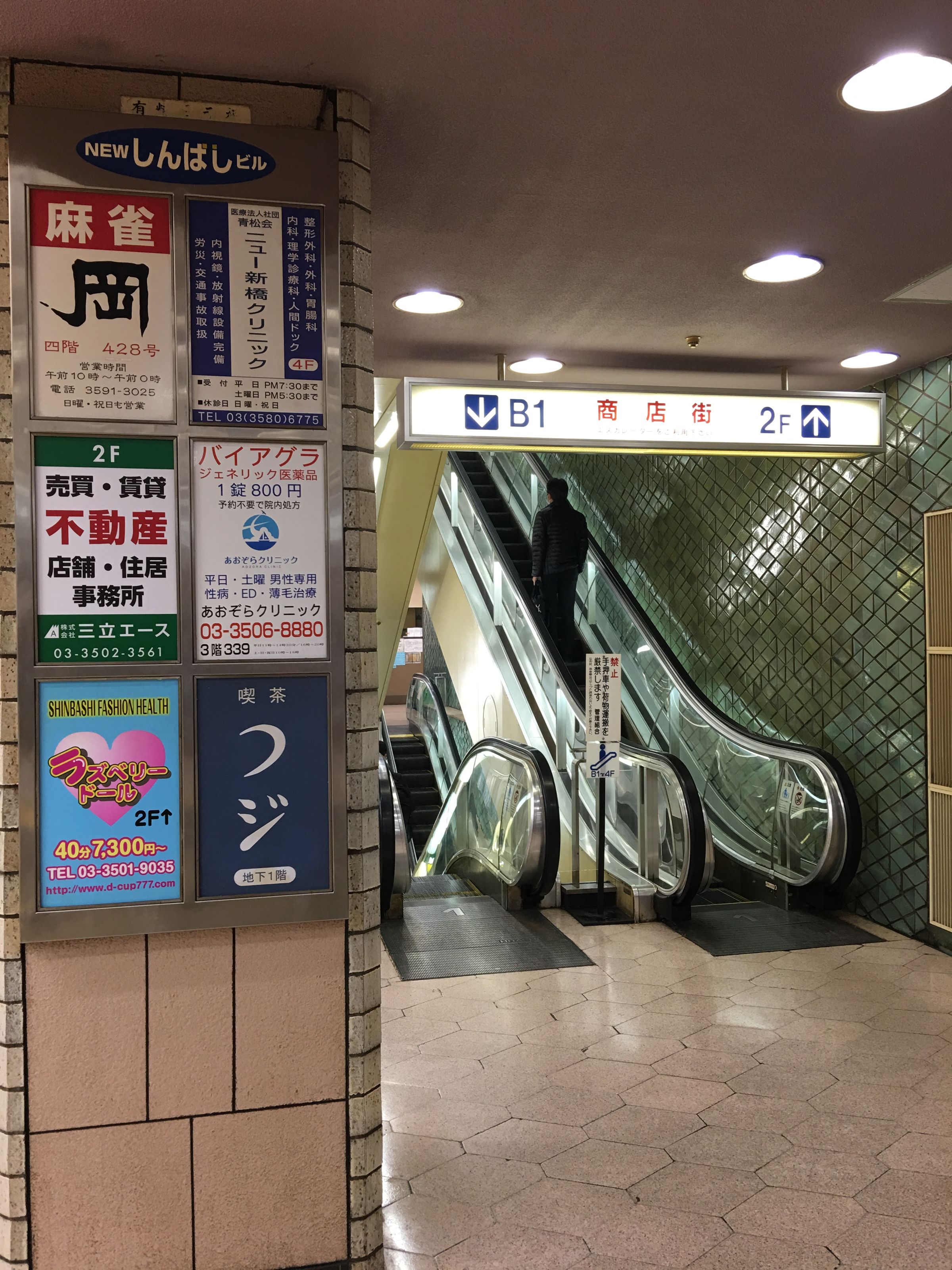 「New新橋大樓」入口看板廣告，從「麻將」、「威而鋼」到「Fashion Health」情色服務，內容五花八門，反映其早年黑市遺址的作風。