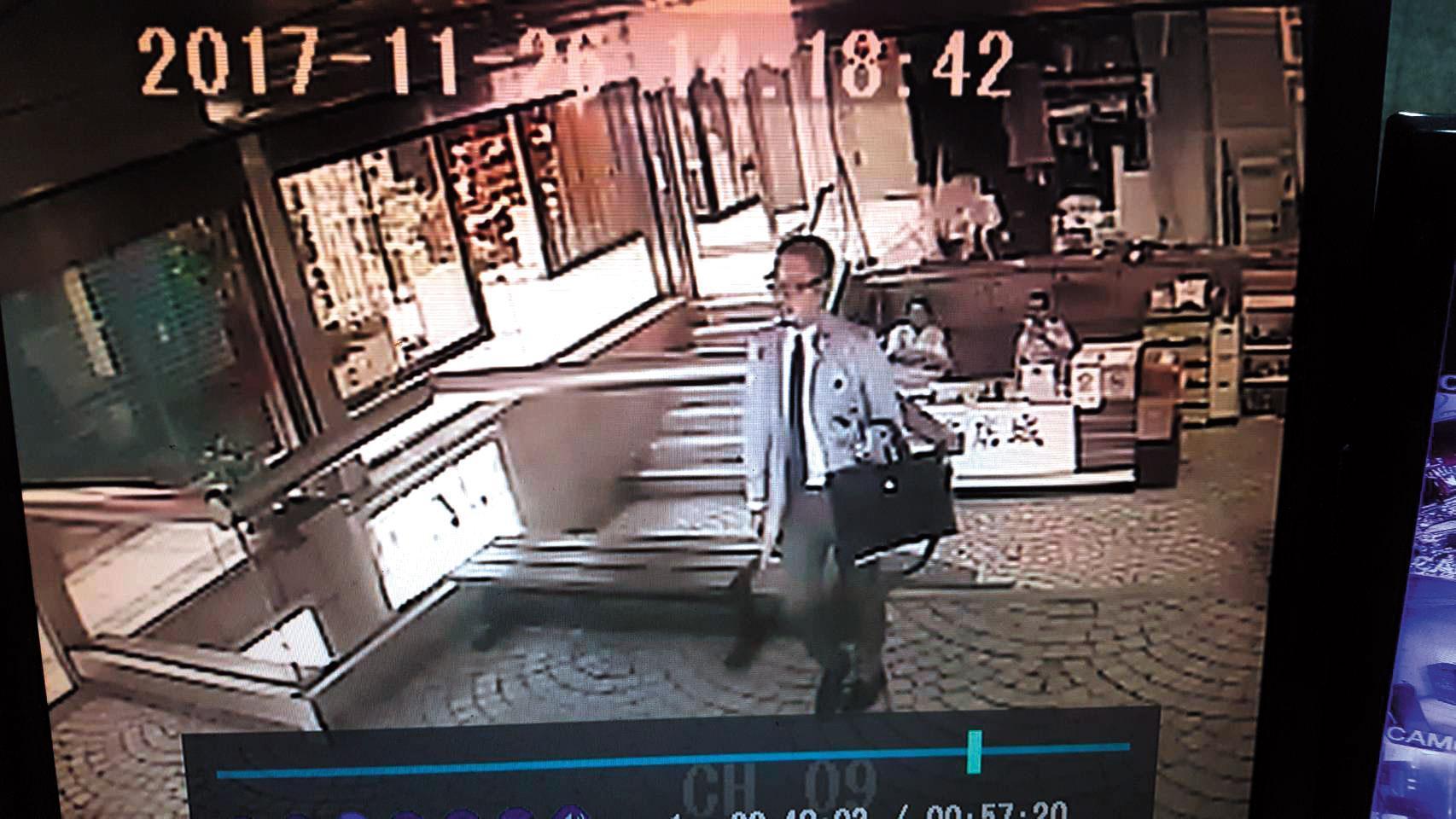 張威欽西裝筆挺出現在蘇先生店裡,佯稱寄賣精品,藉此搭訕認識。(翻攝畫面)