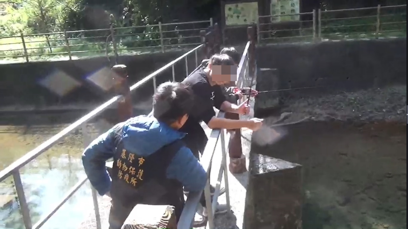 動保所檢察員趕到時，2名學生還在下竿。（基隆動保所提供）