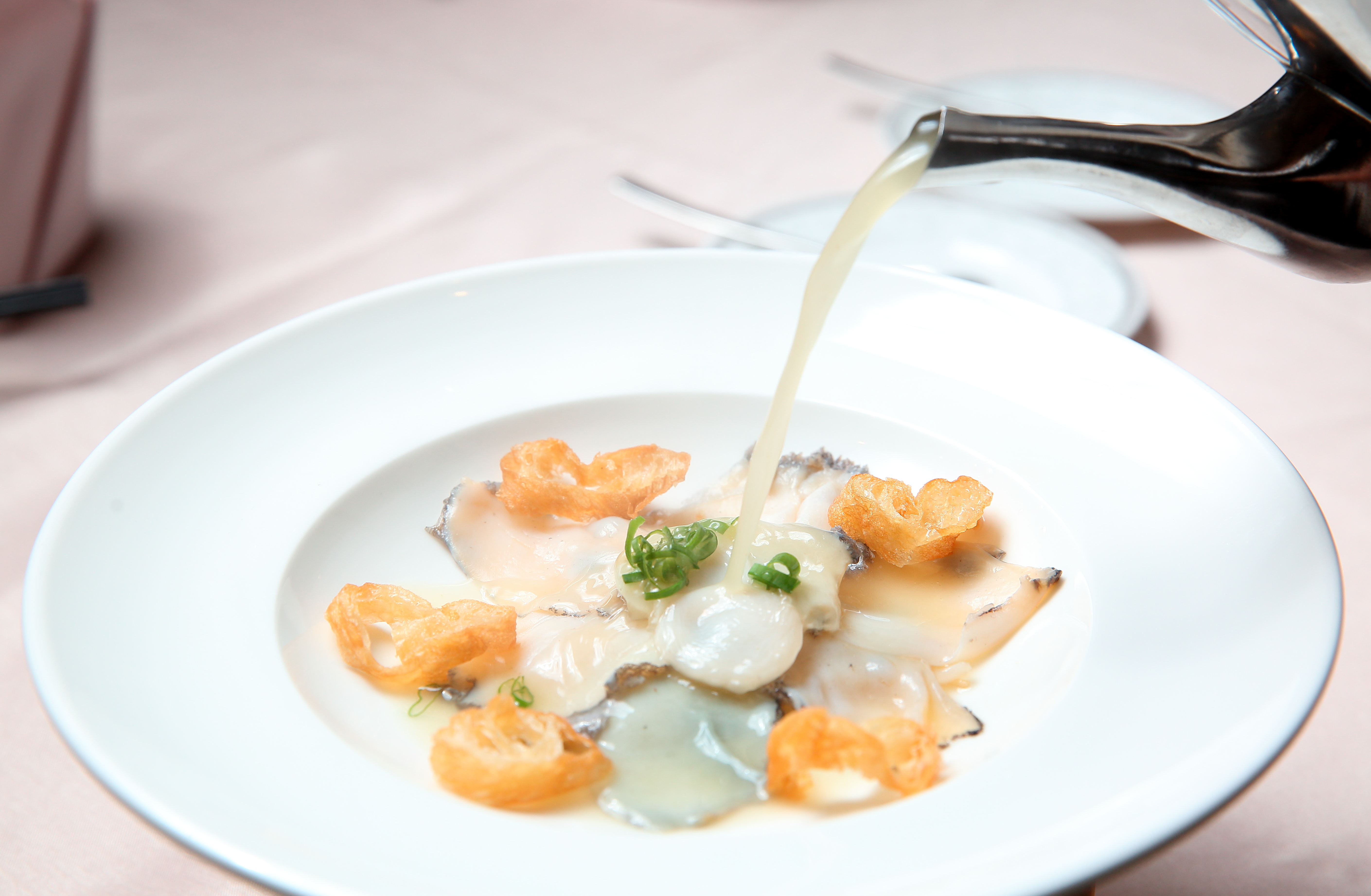 「過橋活鮑魚」是以熬製許久的老母雞湯，熱燙鮑魚片，非常爽口。（780元／份）