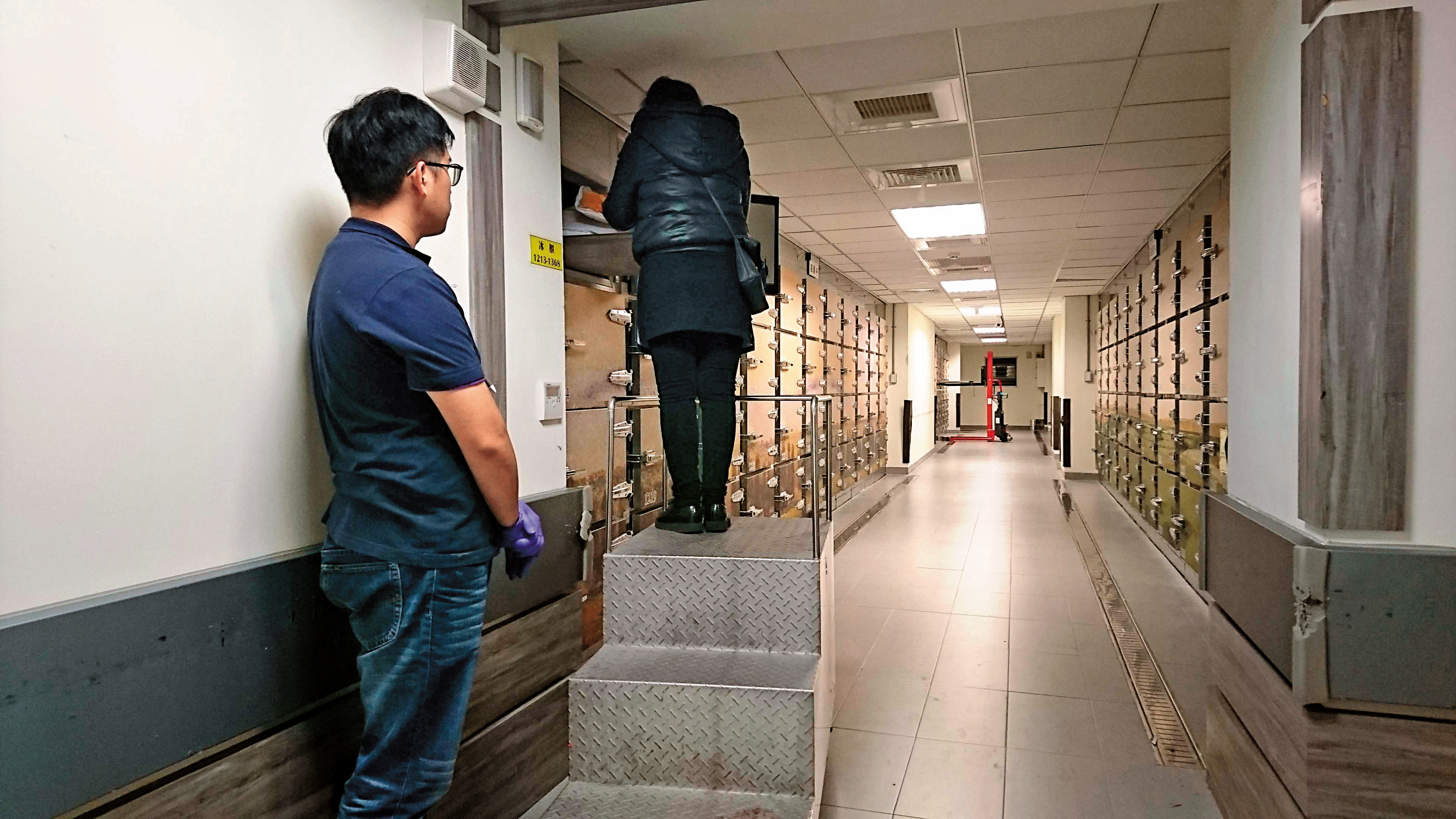 羅女看著冰櫃中已經發黑的丈夫遺體，泣訴和繼子撕破臉的情形。