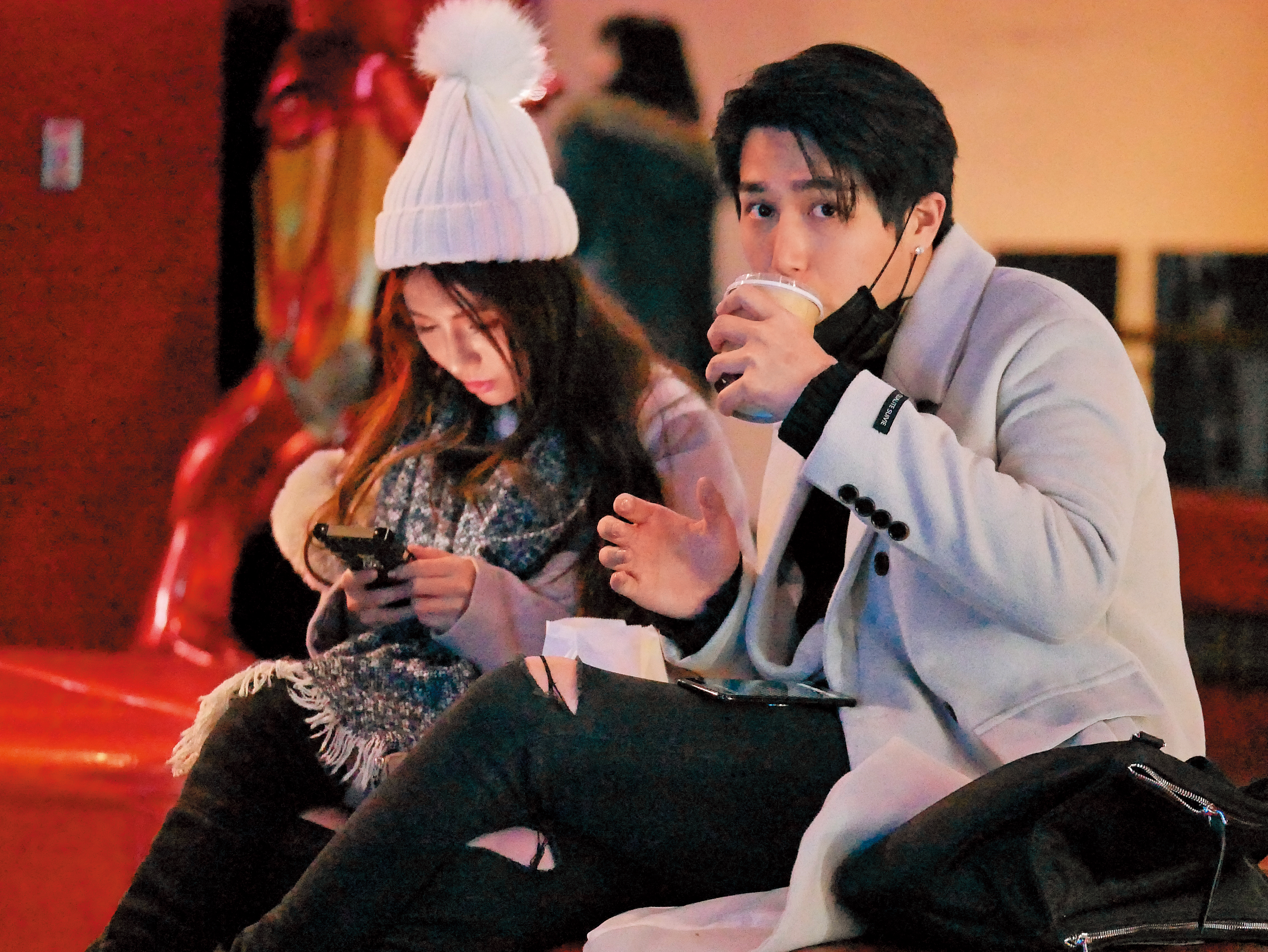 周盈欣和男友等看電影，周穎欣低頭滑手機，男友拿下口罩喝飲料，模樣激似李玉璽。