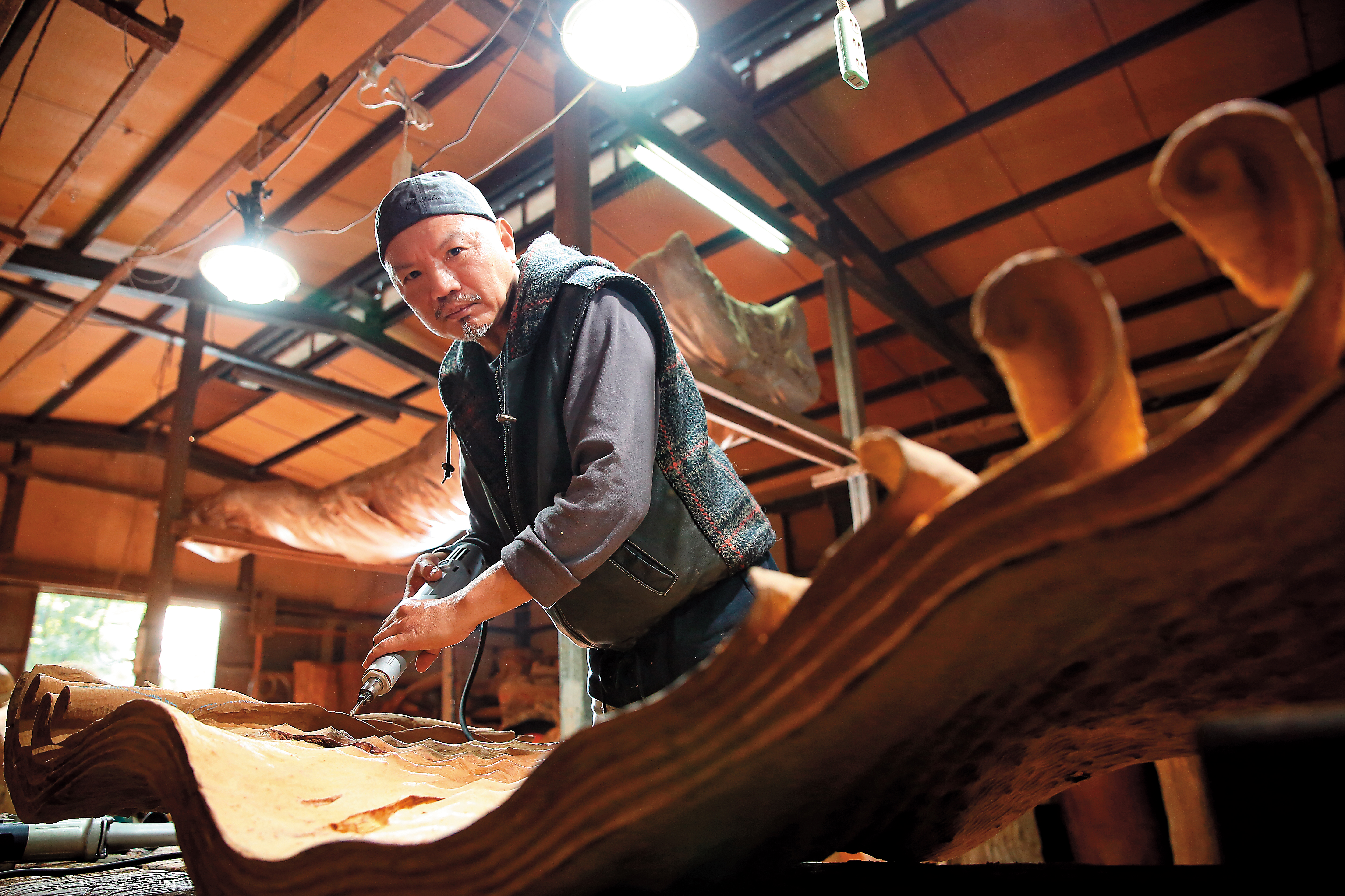 梁平正醉心於木雕創作，但他的前半生曾經當過建商，也曾睡公園四處流浪。