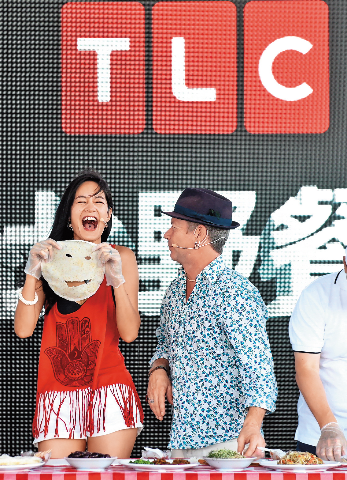Janet（左）的魅力在於，就算是出包了，效果反而會更好。例如她跟伊恩萊特（右）同台示範潤餅，卻把潤餅意外做成了面膜。（TLC旅遊生活頻道提供） 