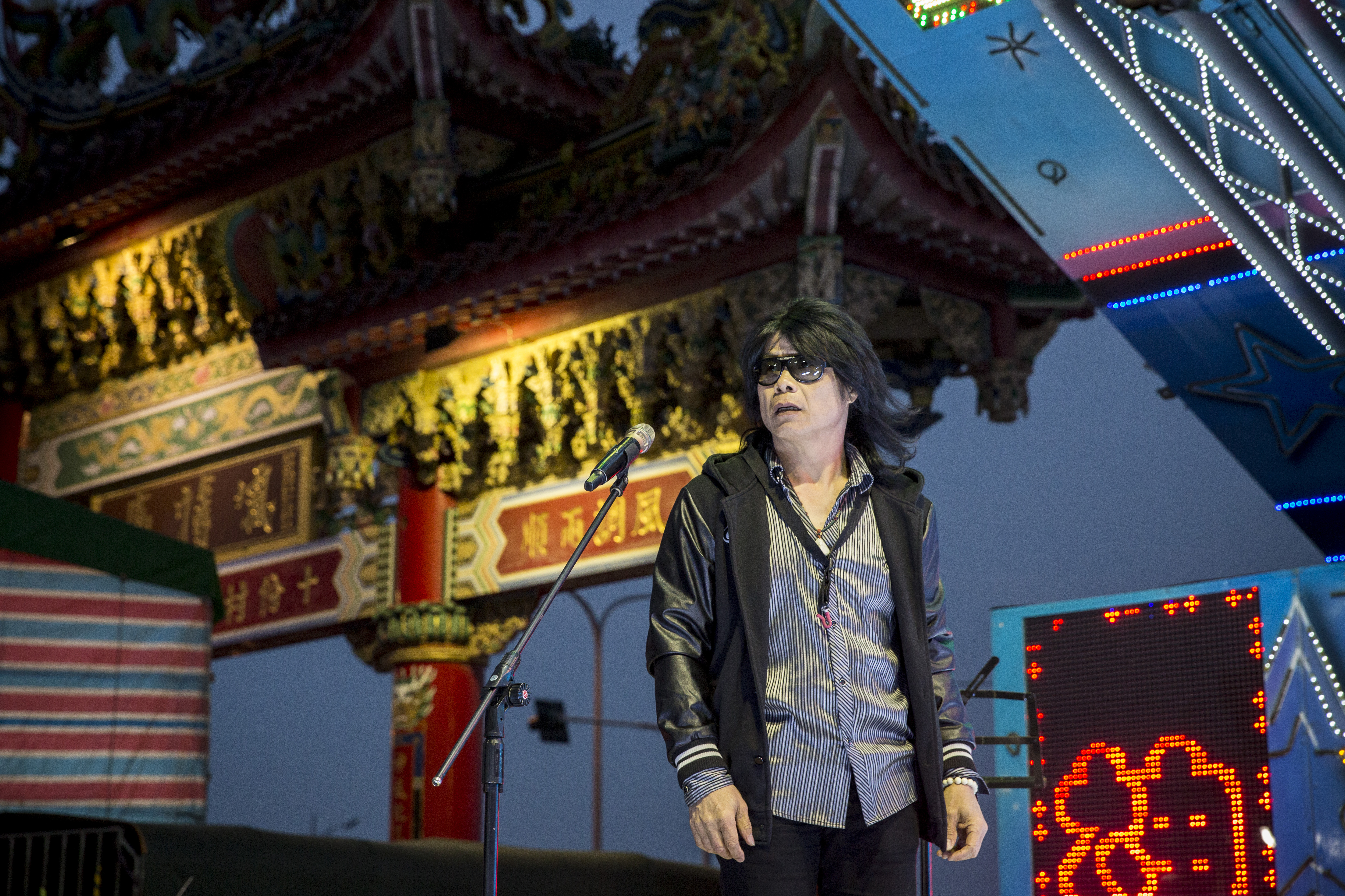 月華光登台測試音響設備，和廟方主委確定活動流程，並指揮樂手和主持人就定位。