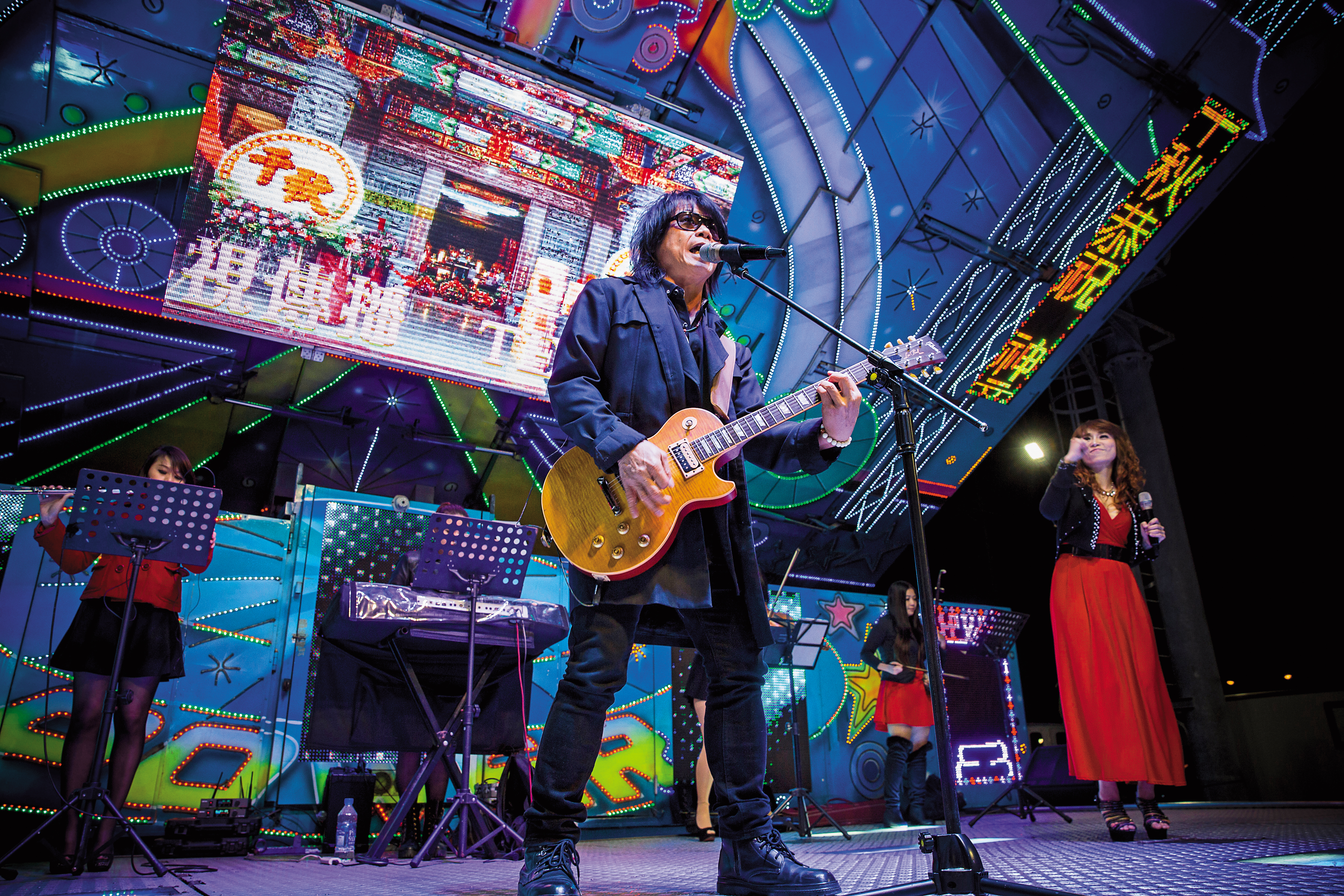 月華光在台南七股海邊的廟會表演，站上燈光閃爍的電子舞台車，高唱伍佰成名曲〈衝衝衝〉。