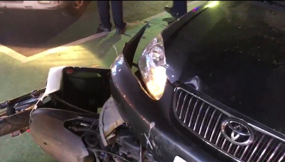 黑色轎車衝撞夜市機車,其中一輛機車還卡在車底,可見衝撞力道猛烈。(警方提供)