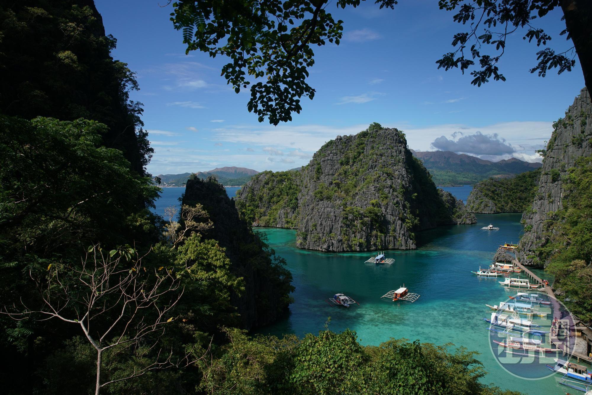 攀爬至石灰岩山峰，從山頂俯瞰海面，海水顏色呈現漸層。