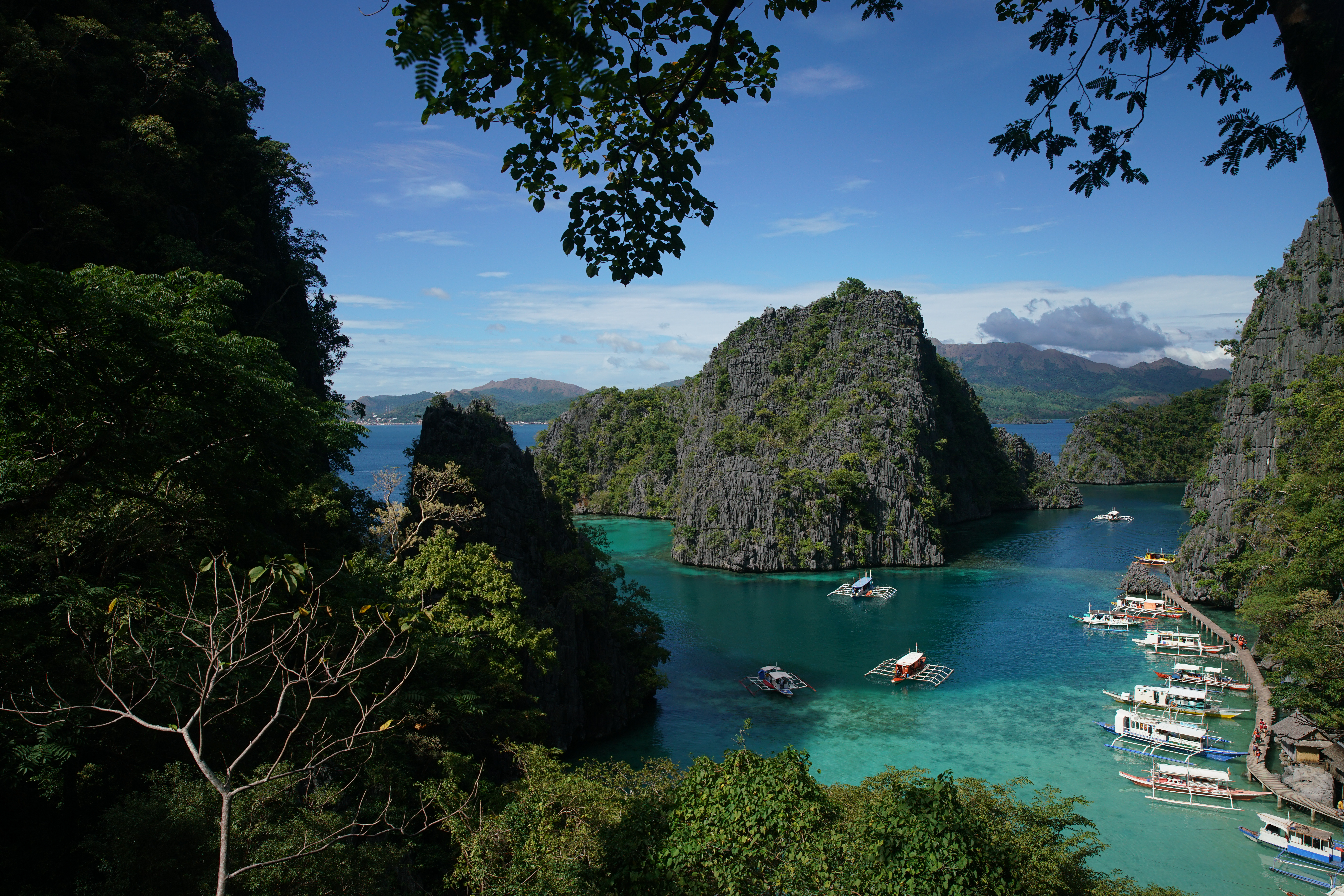 攀爬至石灰岩山峰，從山頂俯瞰海面，海水顏色呈現漸層。