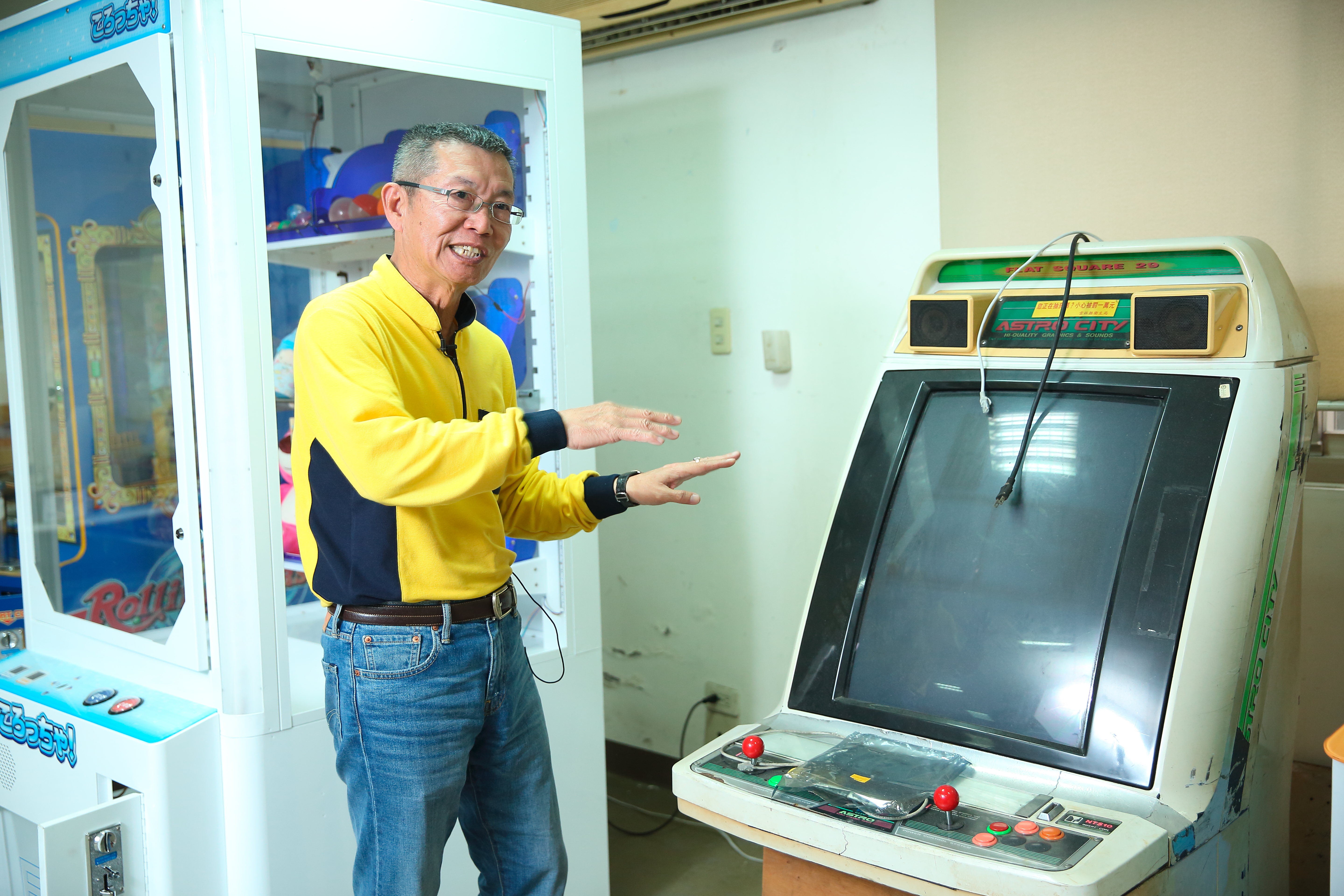 指著舊款的螢幕式電子遊戲機，呂坤謀笑說，自己曾在維修時遭高壓電電飛。