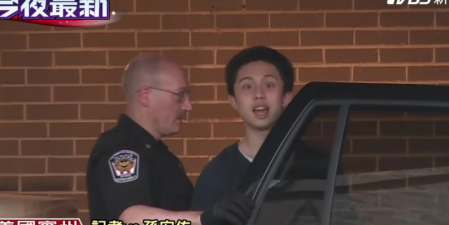 孫安佐被警察趕著上車，拚命想要探頭。（翻攝自TVBS）