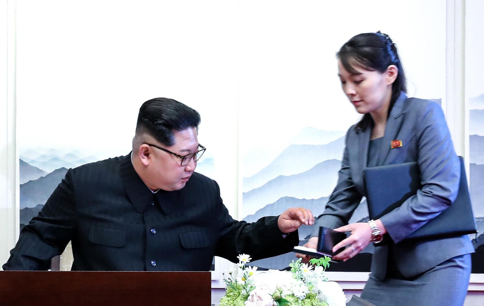 2018年4月28日,北韓領導人金正日在「和平之家」的留言簿簽名題詞,從胞妹金與正手上拿出北韓自備的簽名筆。(東方IC)