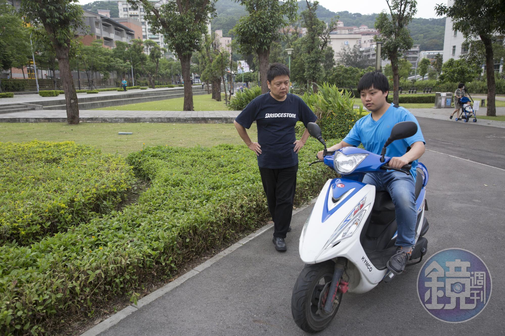 張烈東在公園陪伴兒子練習騎機車,希望他早日獨立。