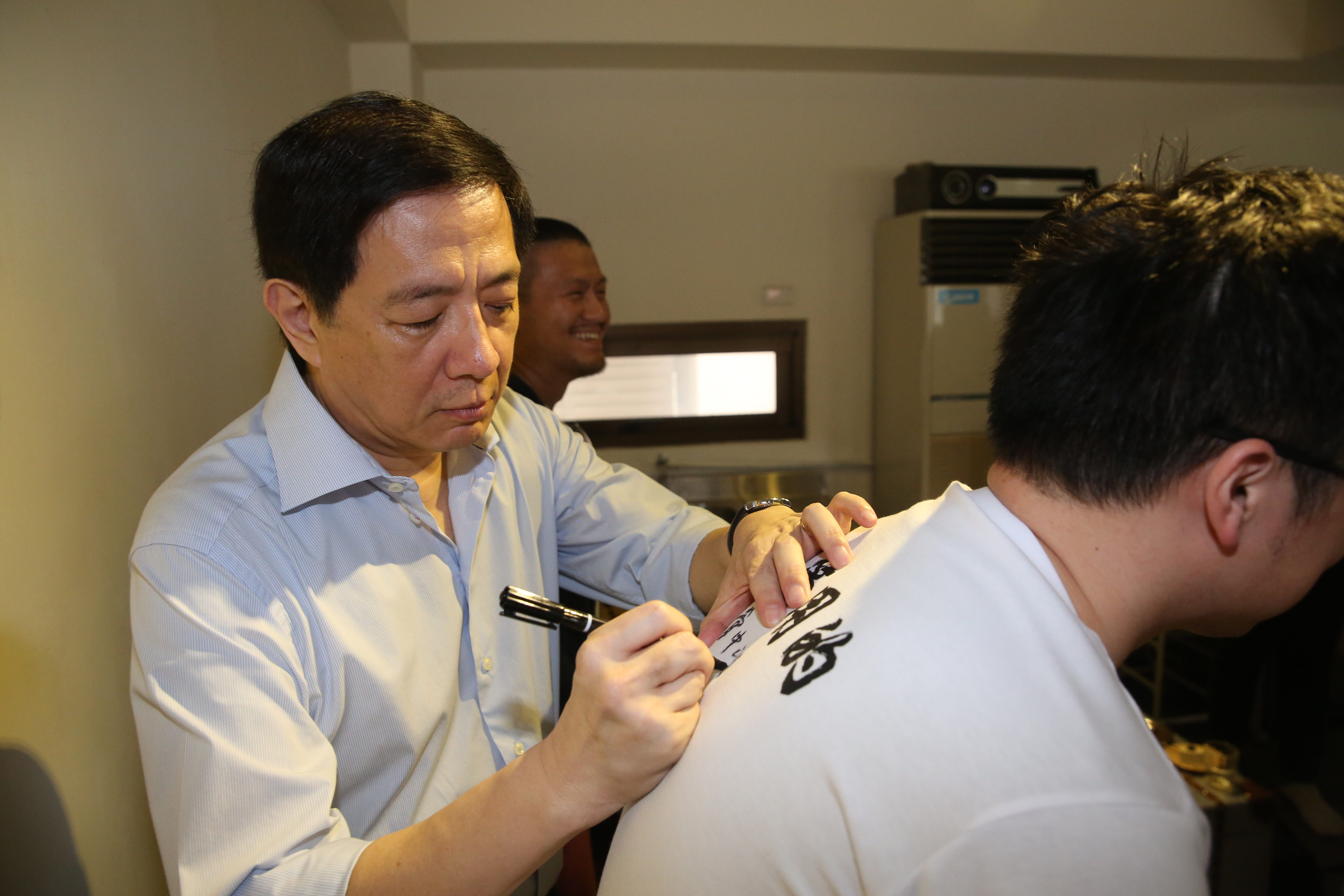 管中閔在茶敘過後，還有台大學生身穿管爺T，並請管中閔在衣服上簽名。