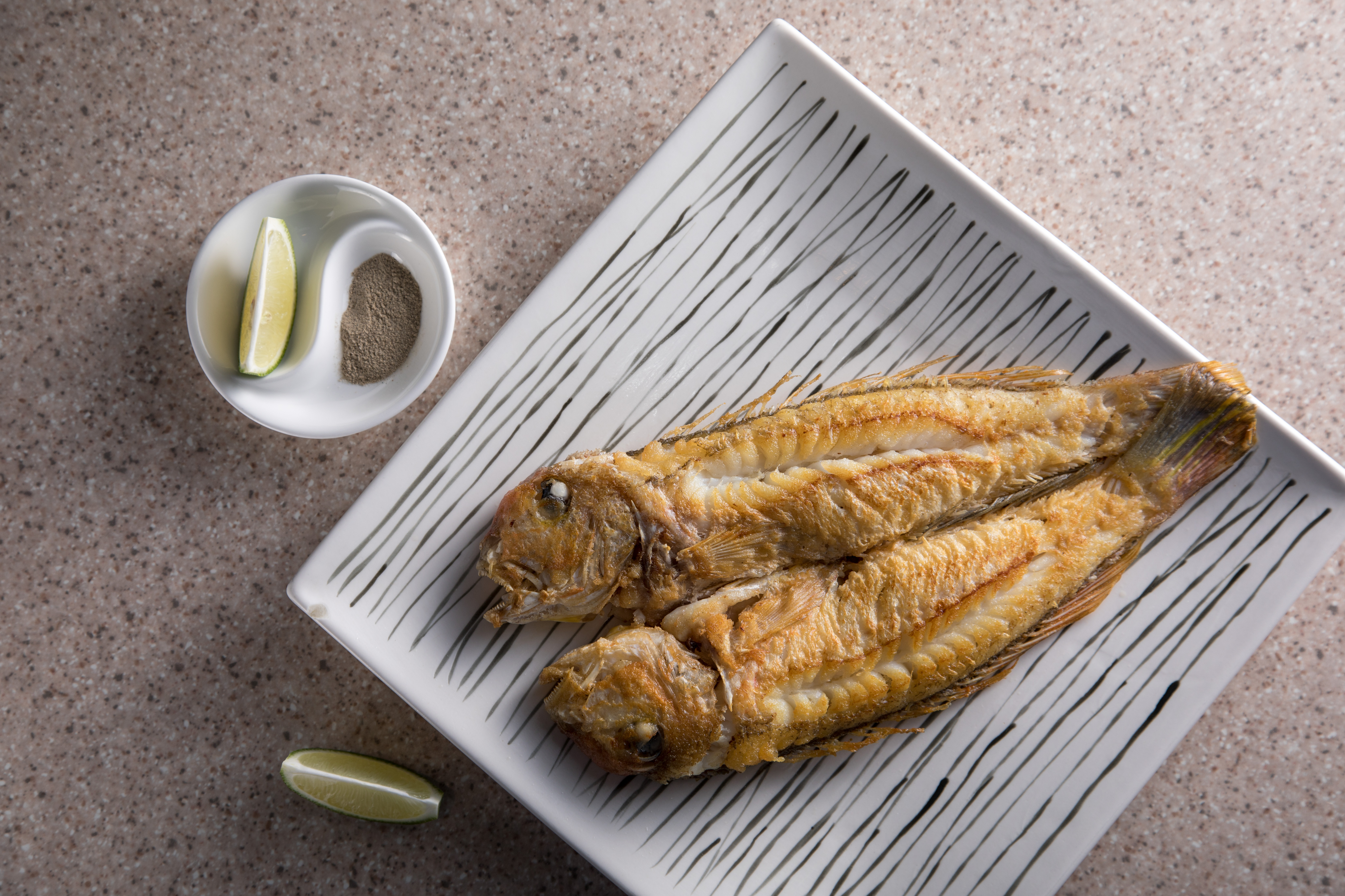 老闆陳宜呈苦心練習出師的「乾煎馬頭魚」，表皮煎出淺金色，魚肉飽滿幼細，還有一點湯汁，很容易掃盤。（時價，圖約1,100元／份）