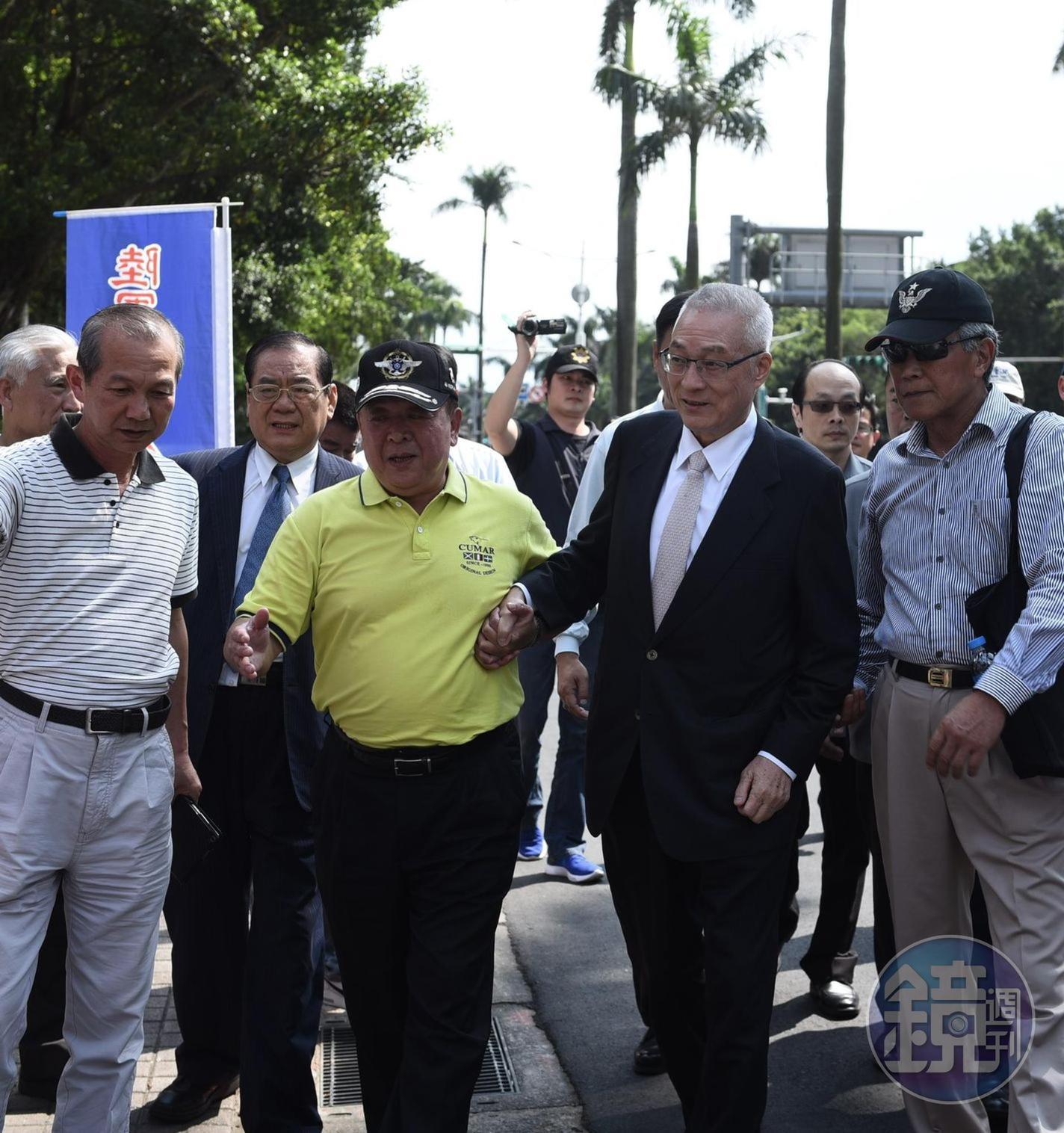 國民黨主席吳敦義最近身體不適，日前赴立法院為反年改團體「八百壯士」加油，還需八百壯士副指揮官吳斯懷攙扶。（翻攝臉書）
