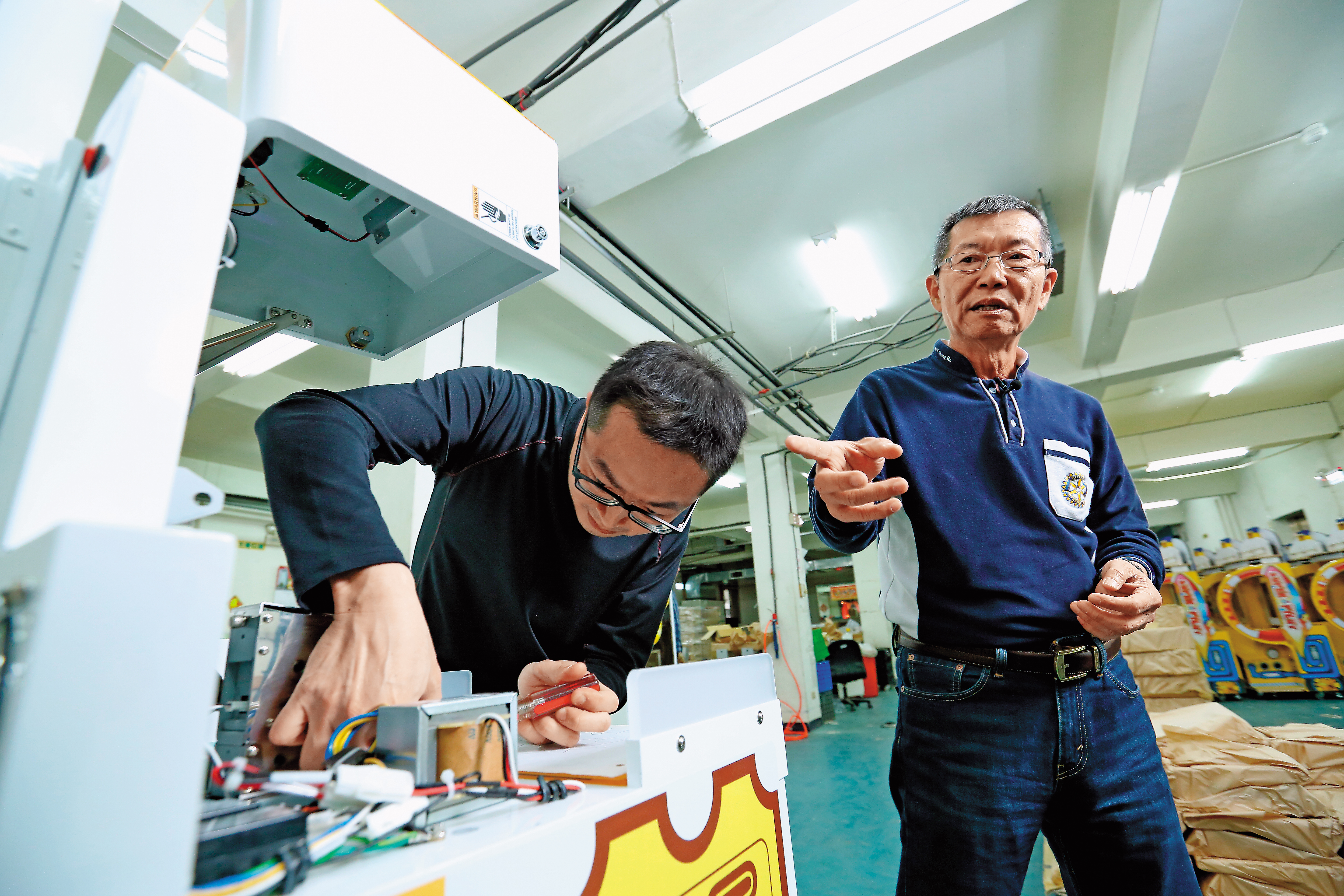 呂坤謀（右）研發的休閒娛樂機台，超過7成外銷歐美日。
