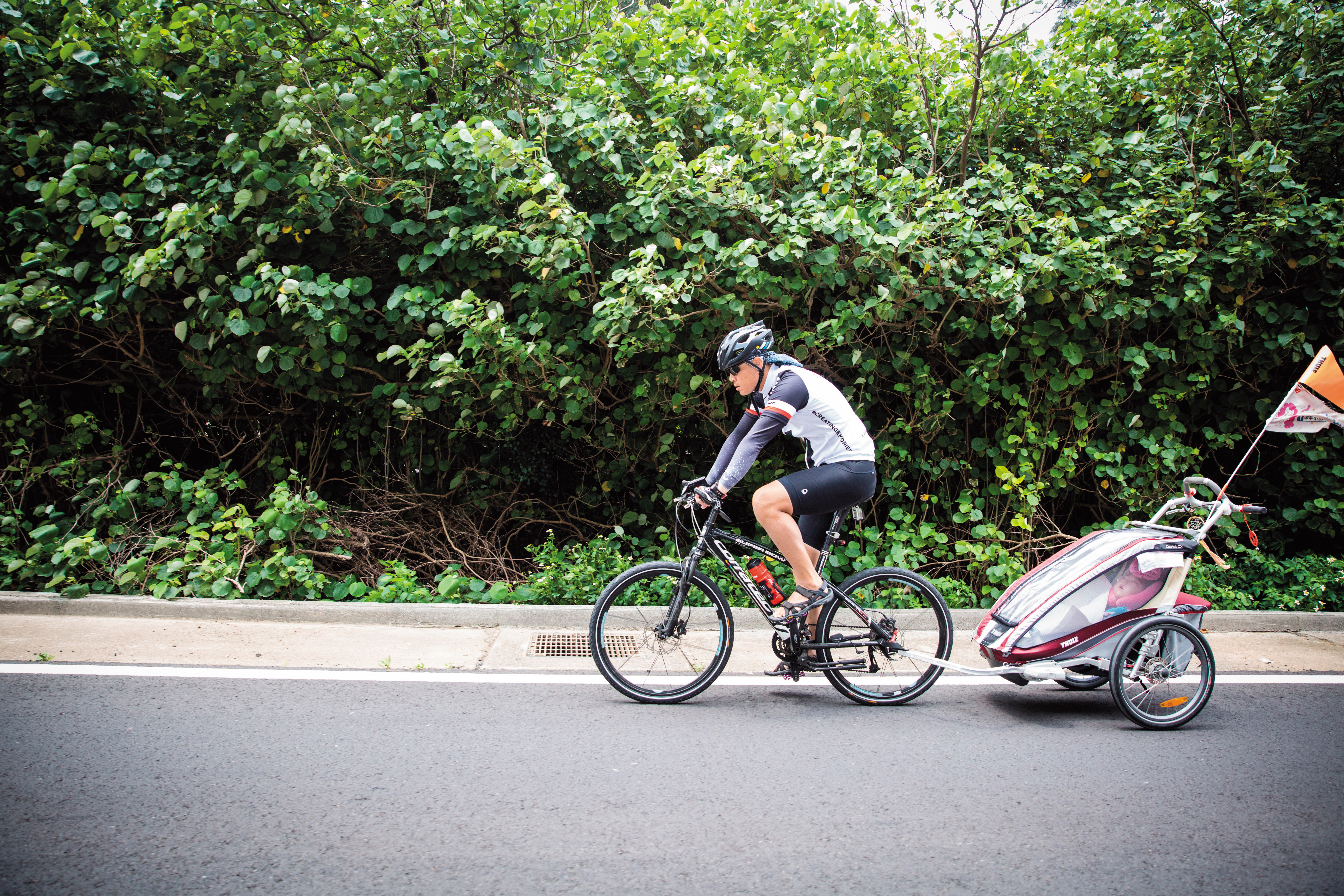 在林芊羽（右）滿4歲前，爸媽決定帶著她一起環島，只要天氣舒適與林芊羽狀況許可，爸爸林冠佑（左）就會把孩子抱上拖車，騎單車載著她感受台灣。