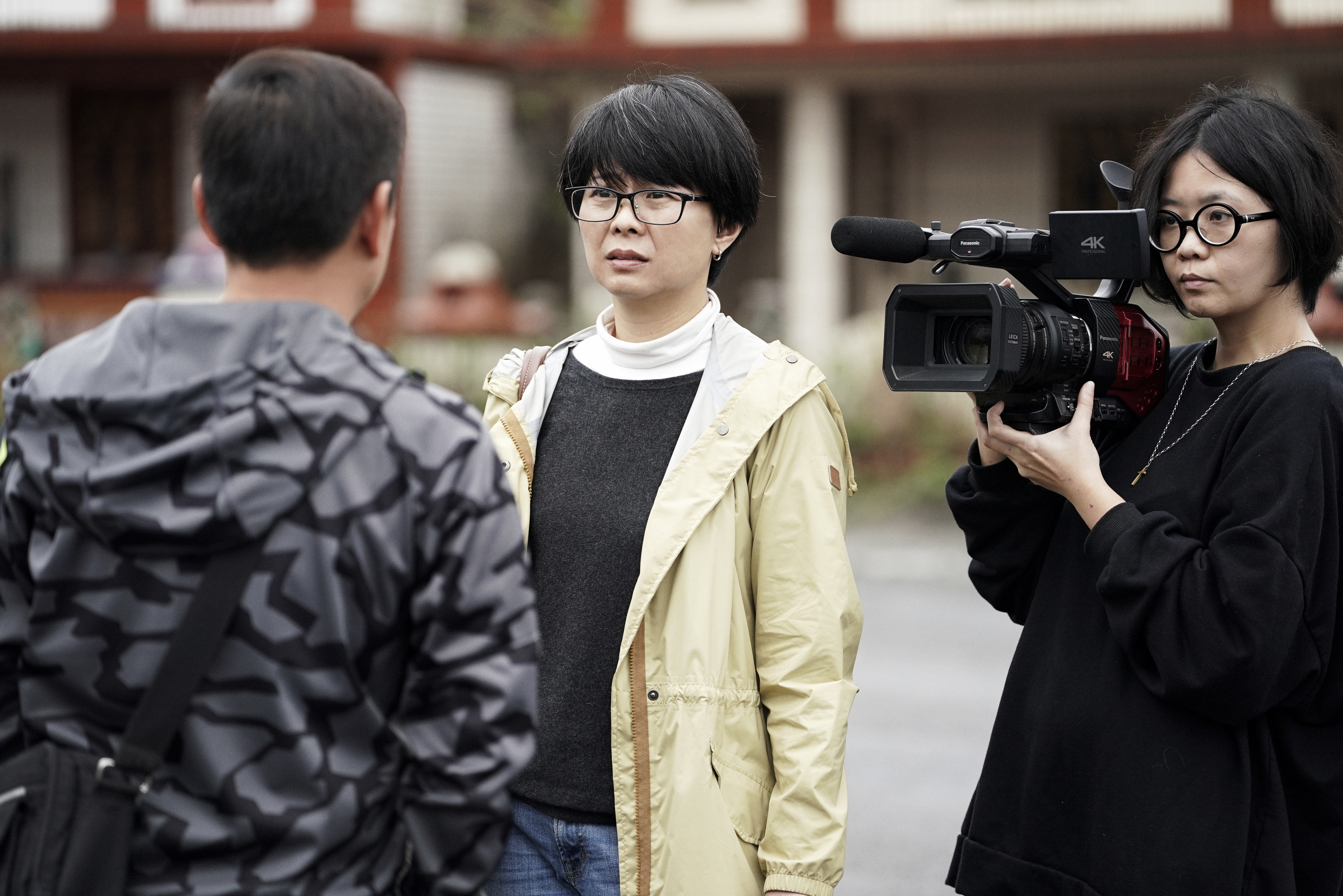 姜秀瓊（中）拍攝《太陽雨》時，一一尋訪大學同學劉智和的親友。（公視提供）