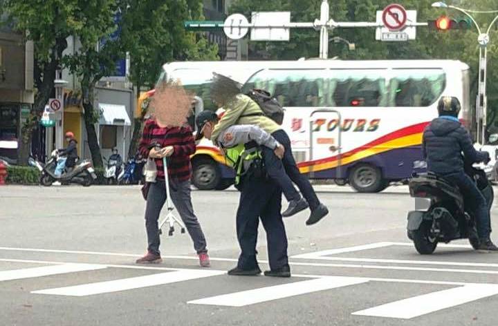 蔡姓員警見綠燈秒數已不足，立即上前背起老婦，護送她安全過馬路。（圖取自爆料公社）