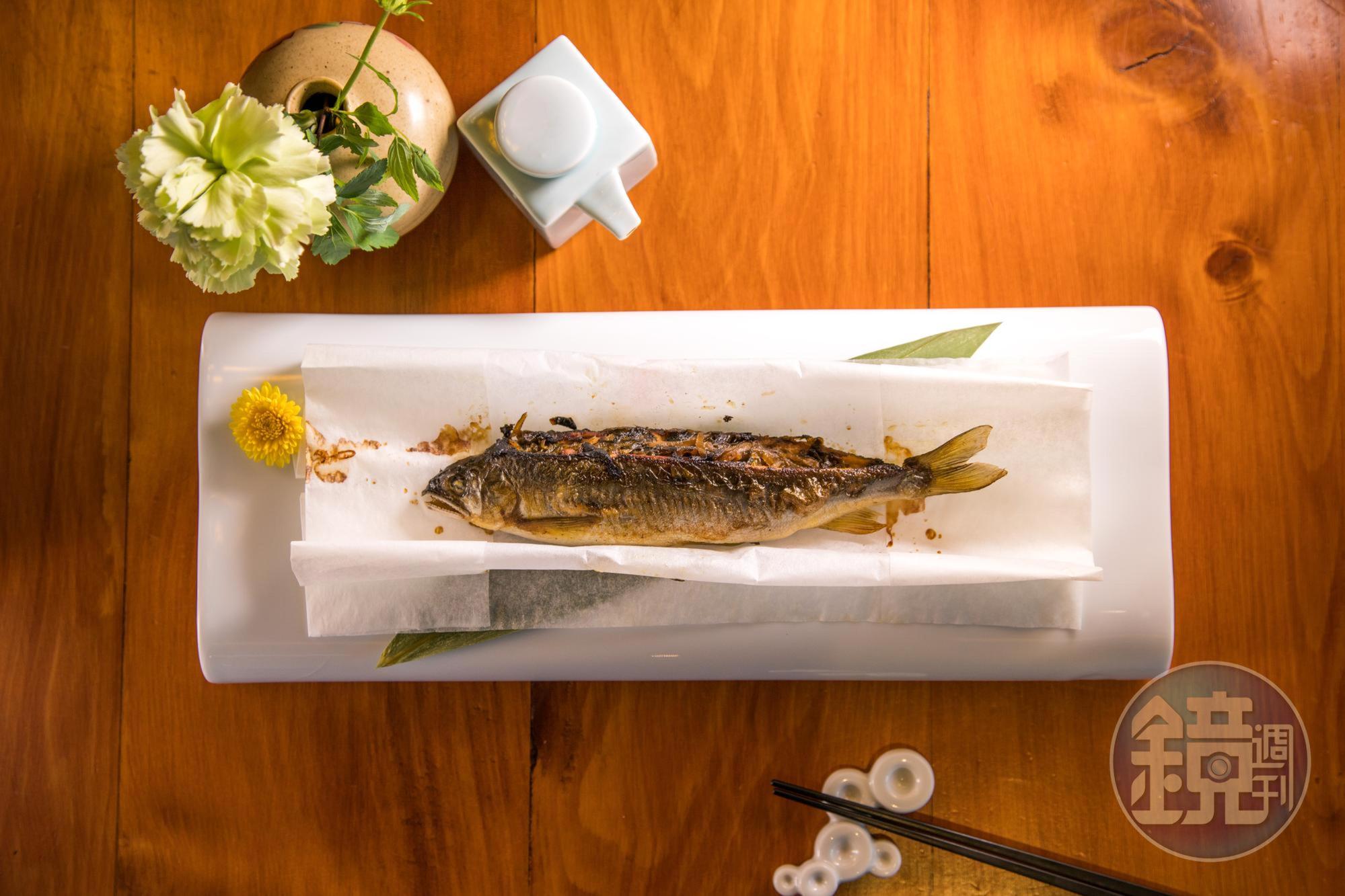 展開卷紙，「酸菜香魚」擺盤如日式料理，抱卵的香魚和酸菜，蘸著壺底油入口，帶有台灣菜熟悉的醍醐味。