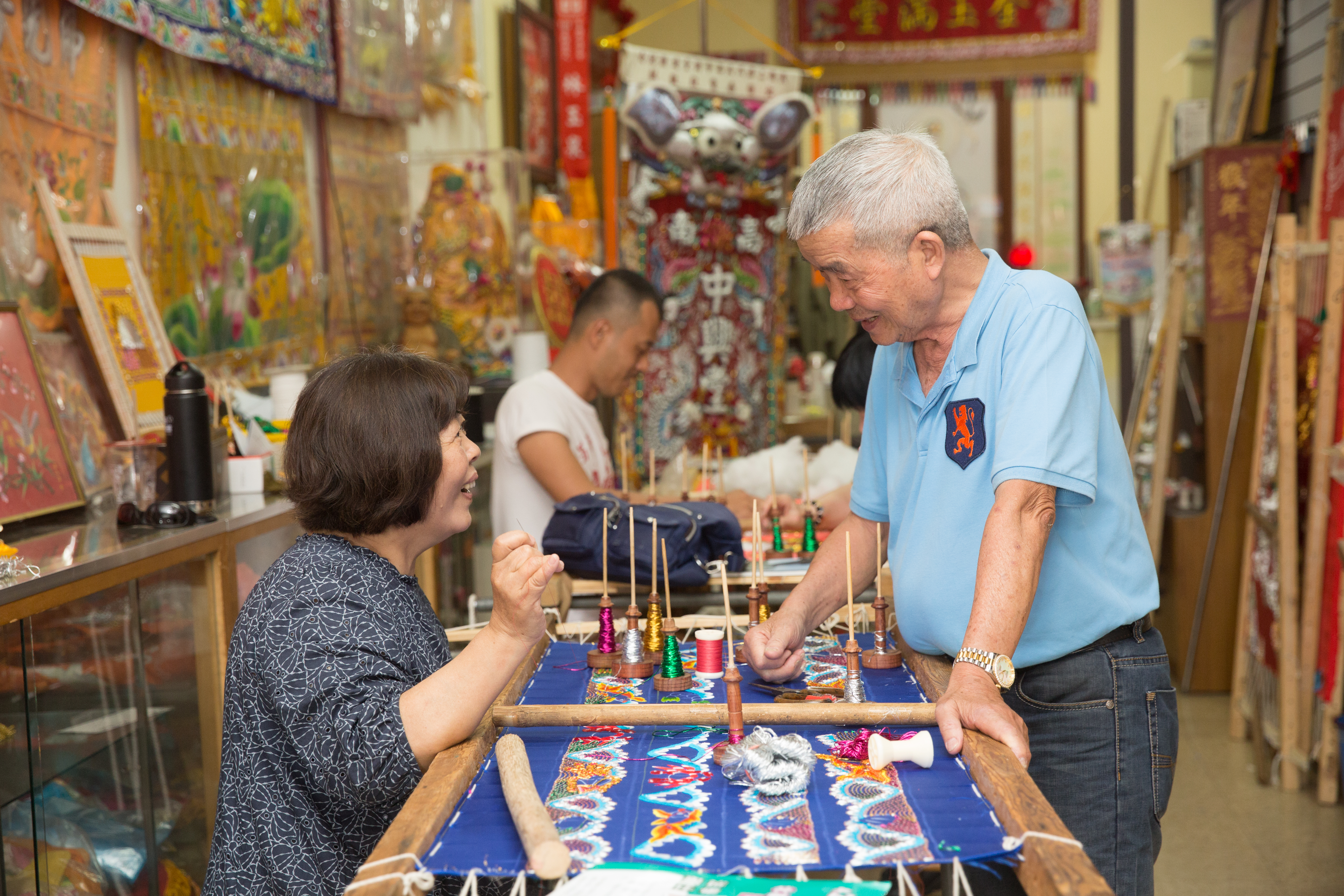 林秋菊（左）是林玉泉最小的妹妹，也是唯一跟著他做刺繡的手足，12歲就開始學習。