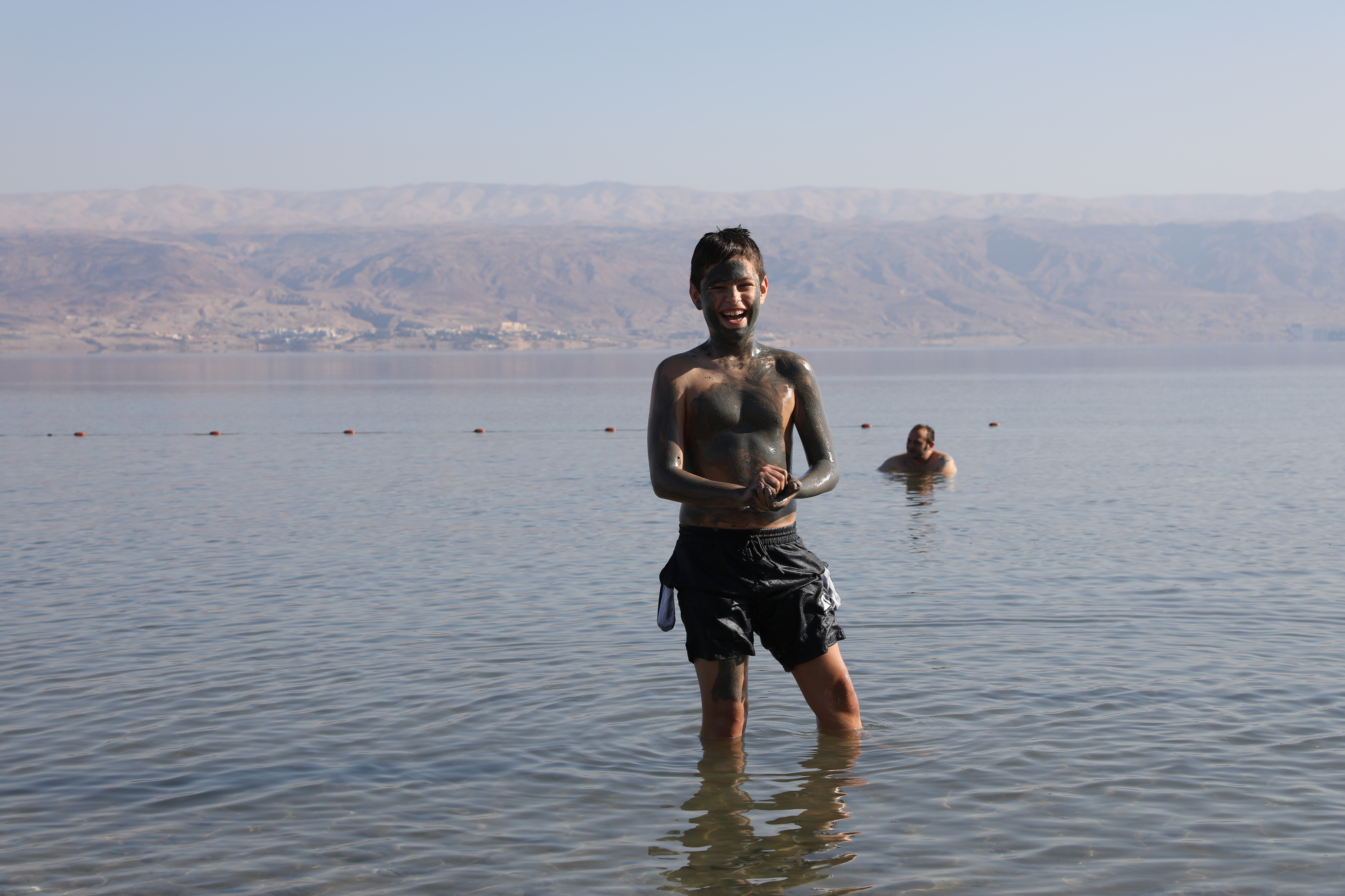 以色列男孩在自己身上塗滿死海泥，自得其樂超開心。