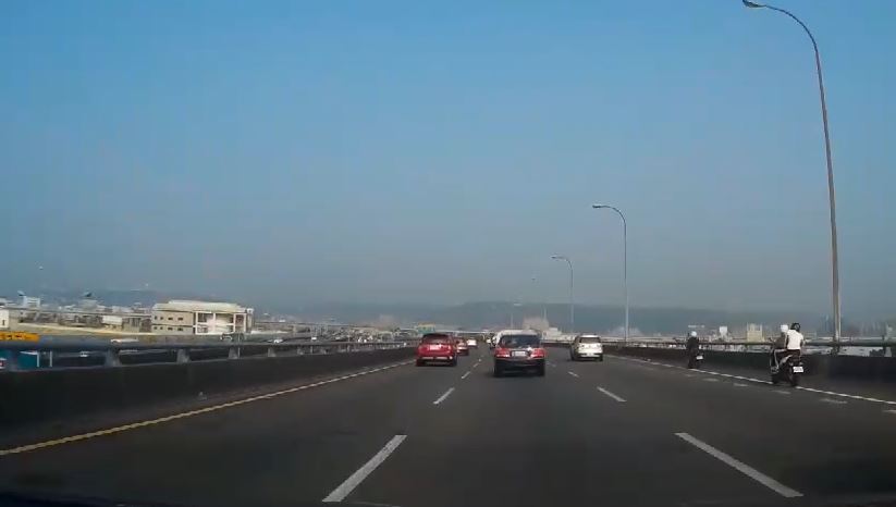 汐五高架南下車道接近五股轉接道附近，驚見兩輛白牌機車在國道上奔馳。（讀者提供）