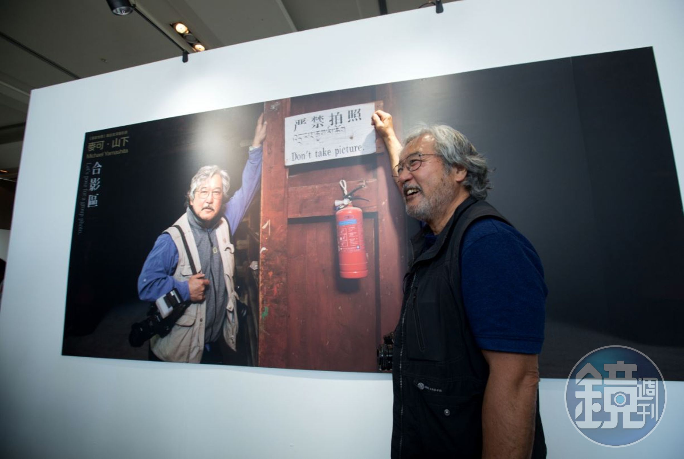 主辦單位在回顧展上安排了一個合影區，照片中的麥可山下站在「嚴禁拍照」的標語旁留影，令人莞爾。