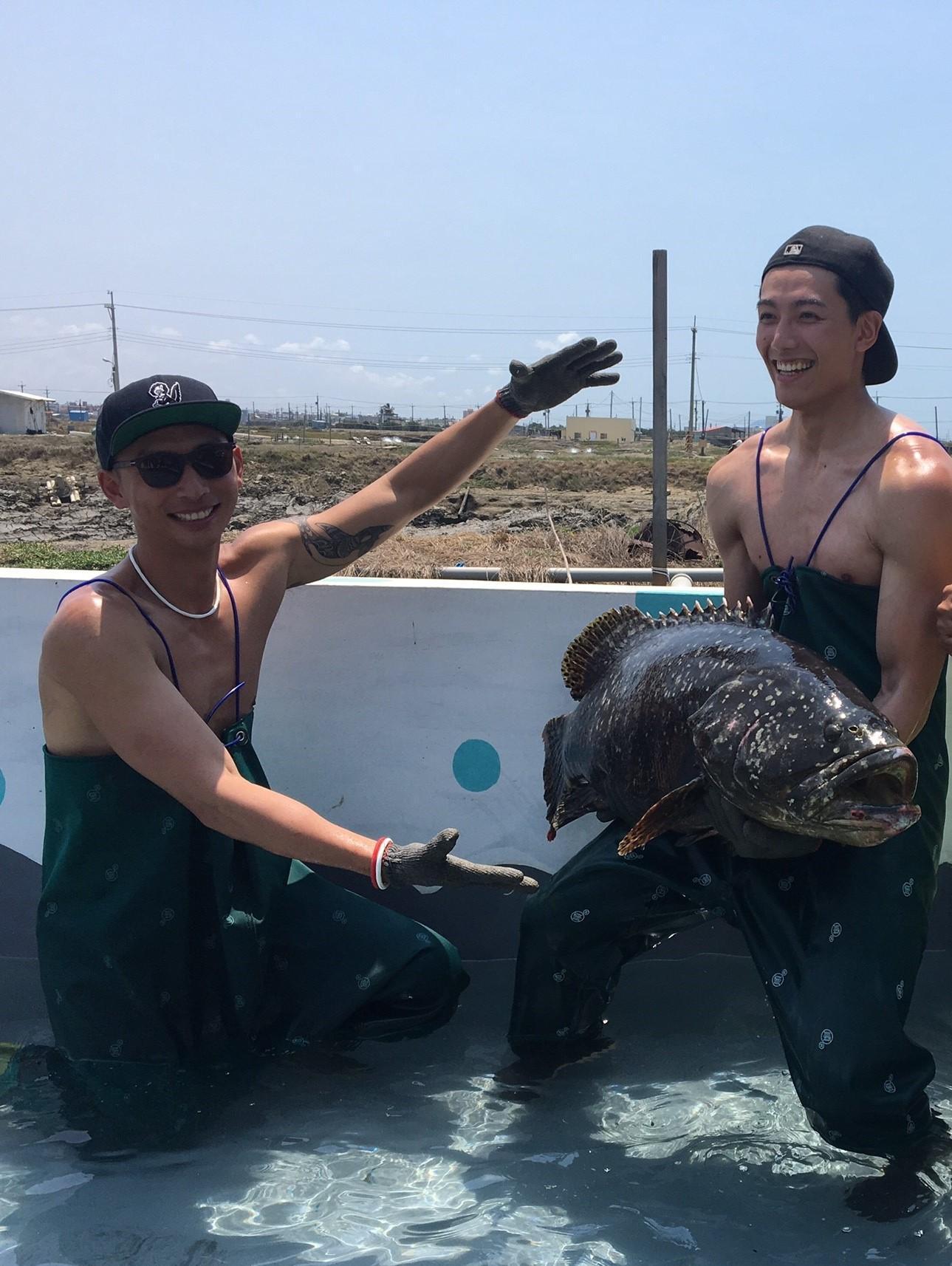 賴東賢（右）手上抱著龍膽石斑魚，畫面頗驚人。左為賴俊龍。（三立提供）