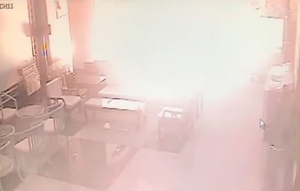 蔡嫌持寶特瓶裝滿汽油點火，朝國民黨中央黨部一樓縱火。（翻攝畫面）