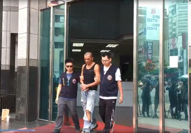 蔡姓男子稱因不滿遭國民黨迫害，到黨部大樓縱火，被警方押送至檢方複訊。（翻攝畫面）