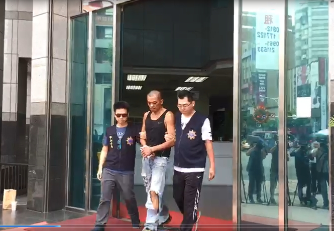 蔡姓男子稱因不滿遭國民黨迫害，到黨部大樓縱火，被警方押送至檢方複訊。（翻攝畫面）