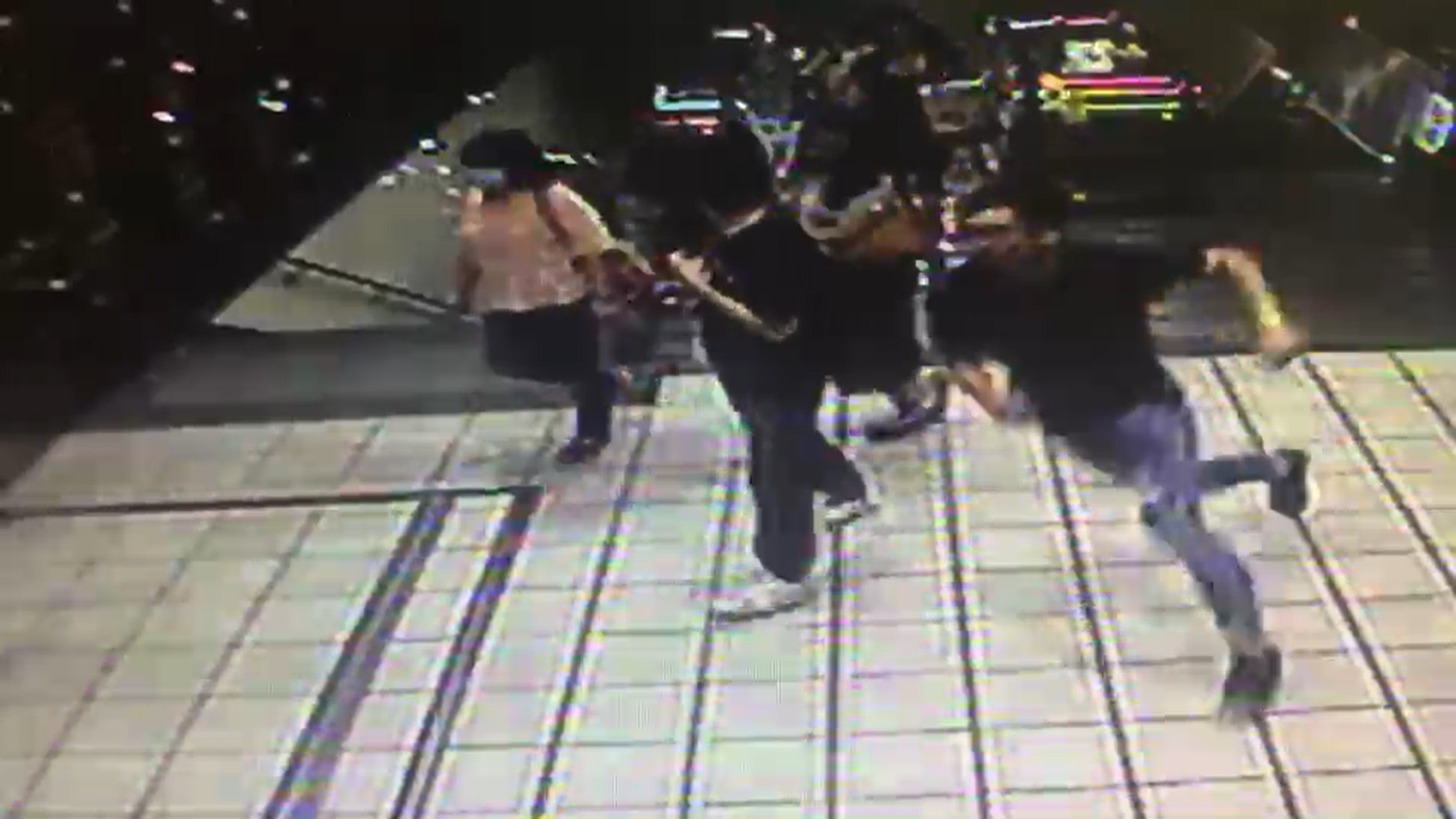 身穿黑色上衣的男子疑在偷拍洪女的裙底風光時被發覺，沿捷運的手扶梯向出口逃竄。（翻攝畫面）