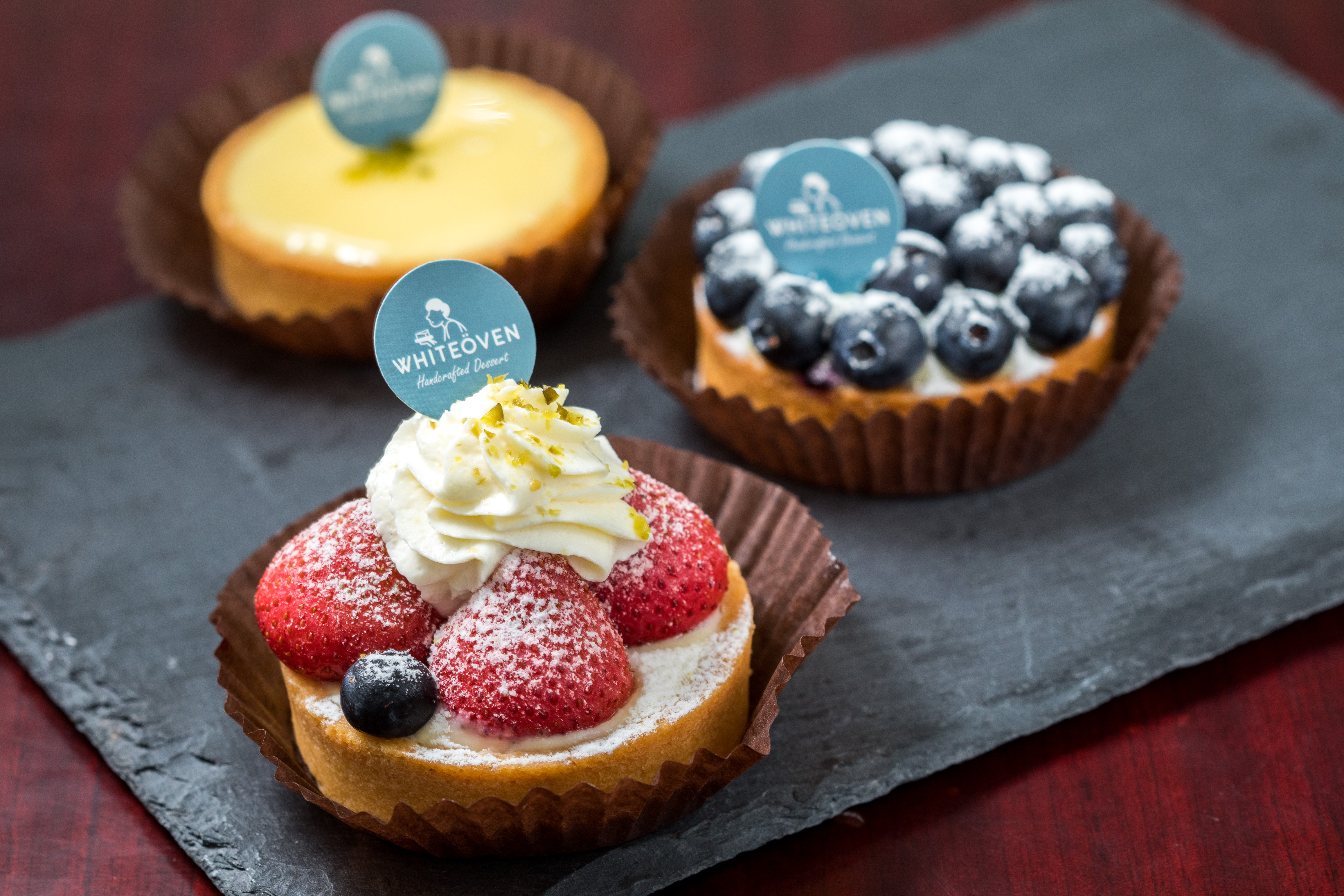 白色烤箱的「草莓塔」（前，120元／個）與「藍莓塔」（中，110元／個）。