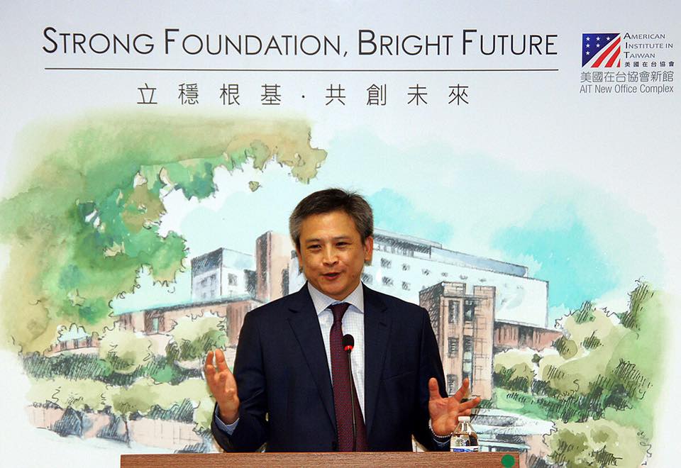 美國在台協會台北辦事處處長梅健華主持AIT四十特展,背景是即將落成啟用的辦事處新館圖像。(facebook/AIT)