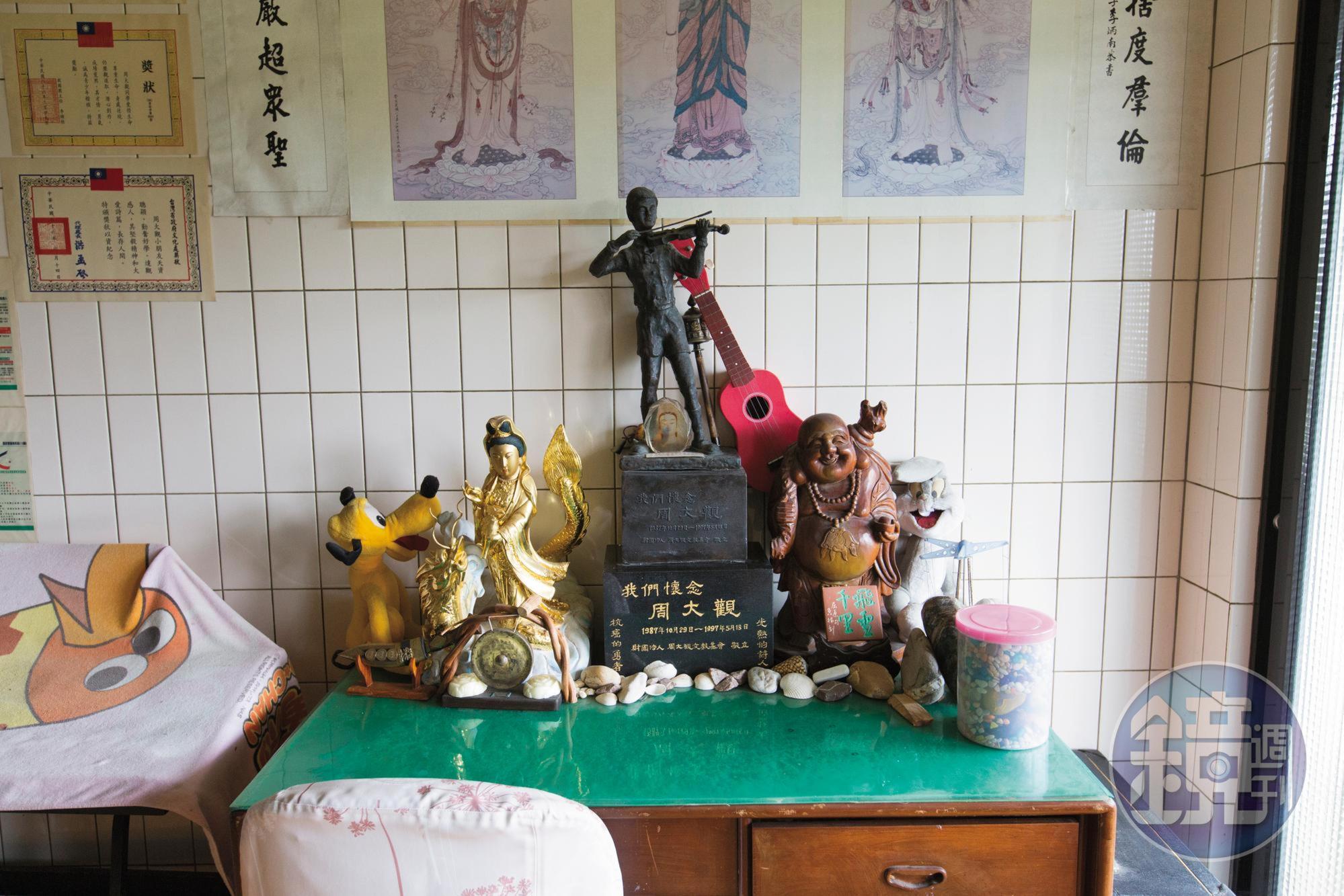 周大觀生前使用過的書桌布置著各種紀念品，雕像下方是他的骨灰。