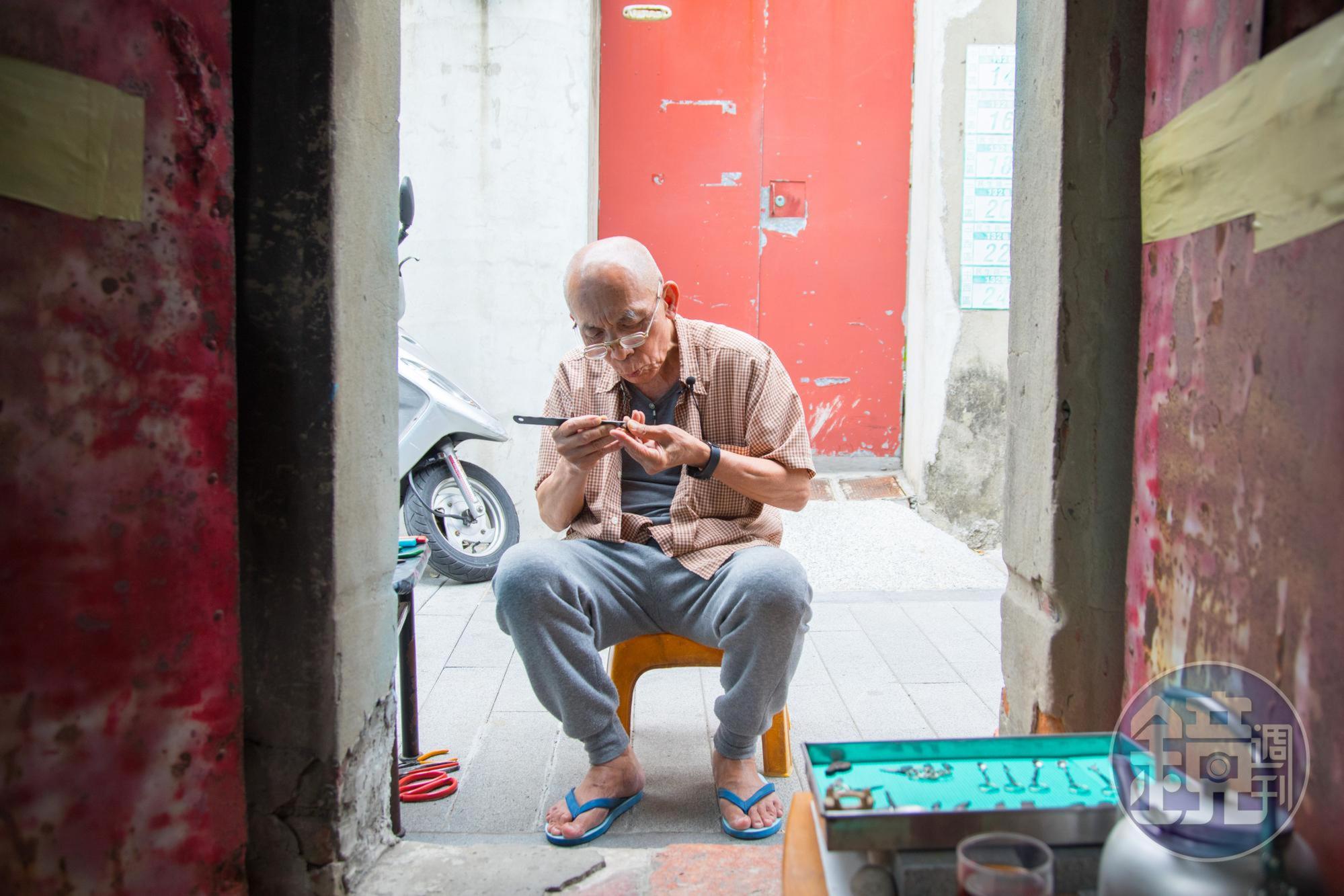 老得伯坐在家門口雕磨菜刀，雖然高齡78歲，創作動力不輸年輕人。