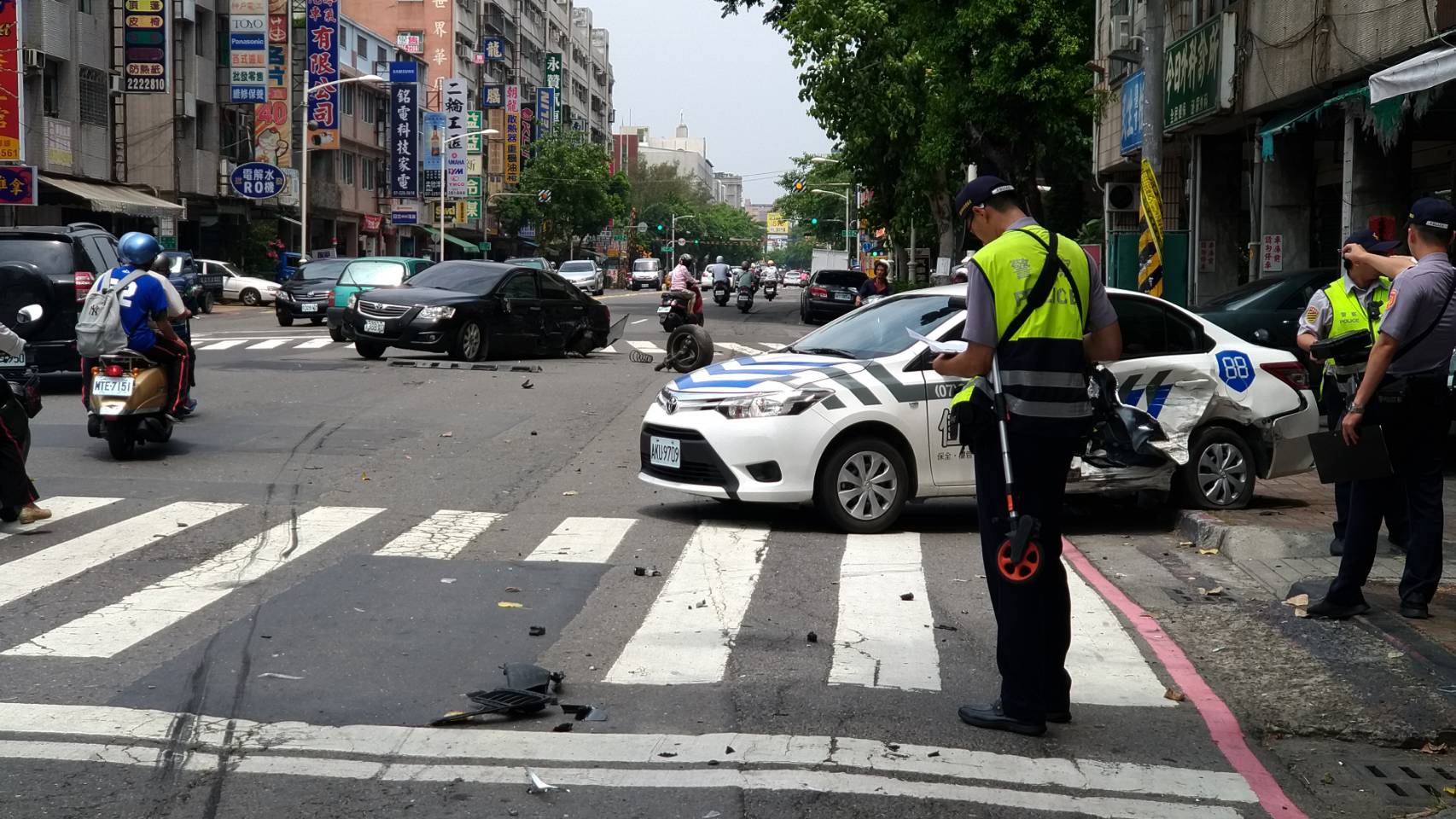 車禍現場凌亂不堪，倒楣的兩輛轎車，車尾毀損嚴重。（警方提供）