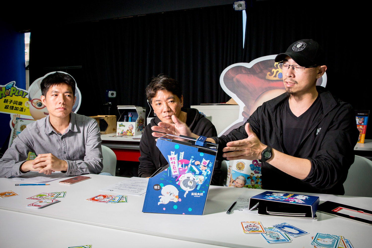 盒子的大小、行動裝置的放置位置都經過不斷改良，HoPLAY執行長林昶龍（右）認為《夜市爭霸》是公司至今最成熟的作品。左為美術組長黃守晟，中為行銷業務經理屈道剛。