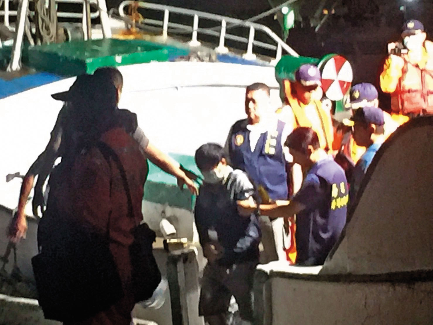 海巡隊逮捕多名越南偷渡客，並從漁船押解上岸。（翻攝畫面）