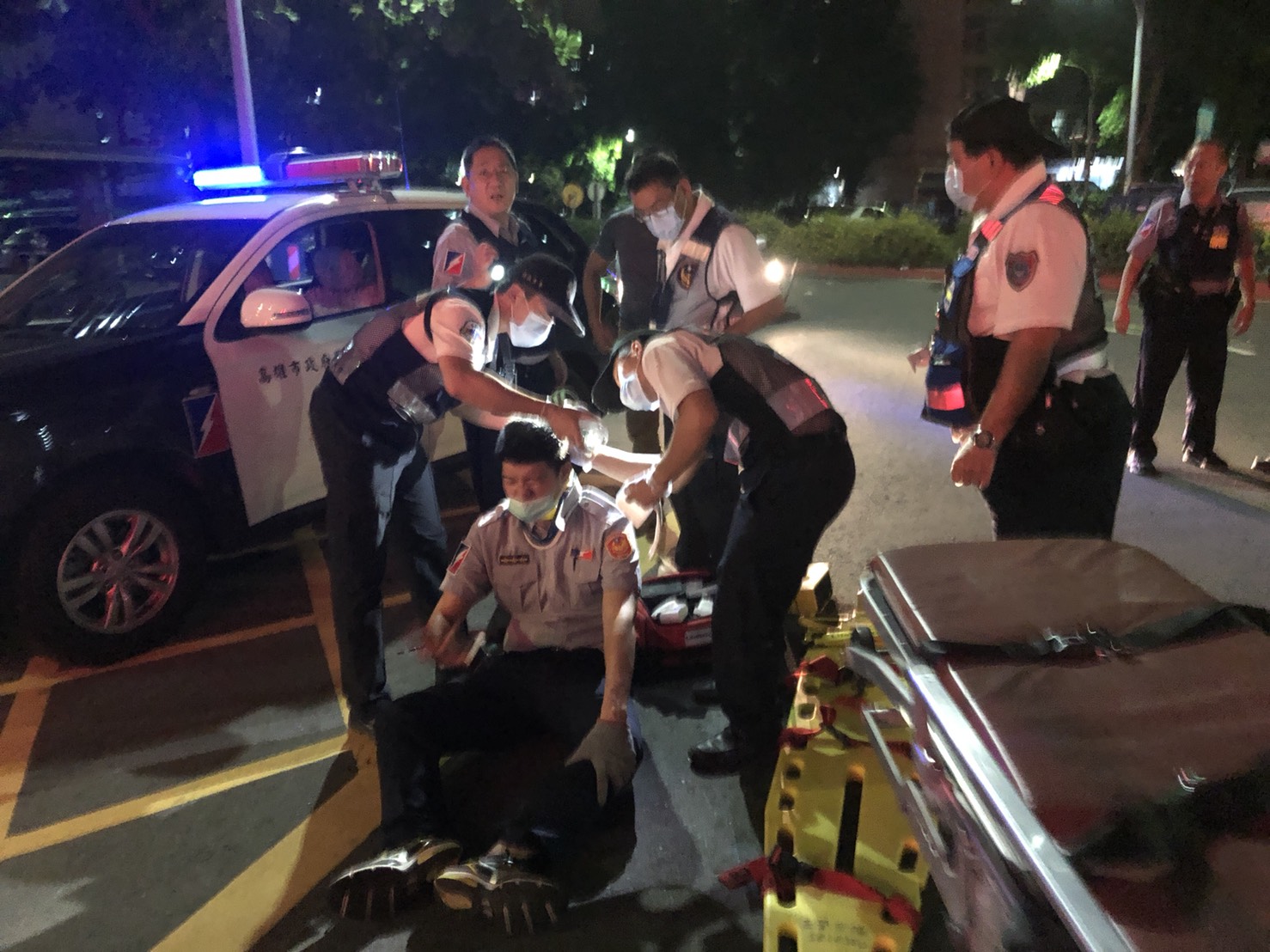 受傷的張姓警員表情痛苦，因為歹徒拒捕駕車逃逸，他攀在轎車蓋遭甩落頭部撞擊。（警方提供）