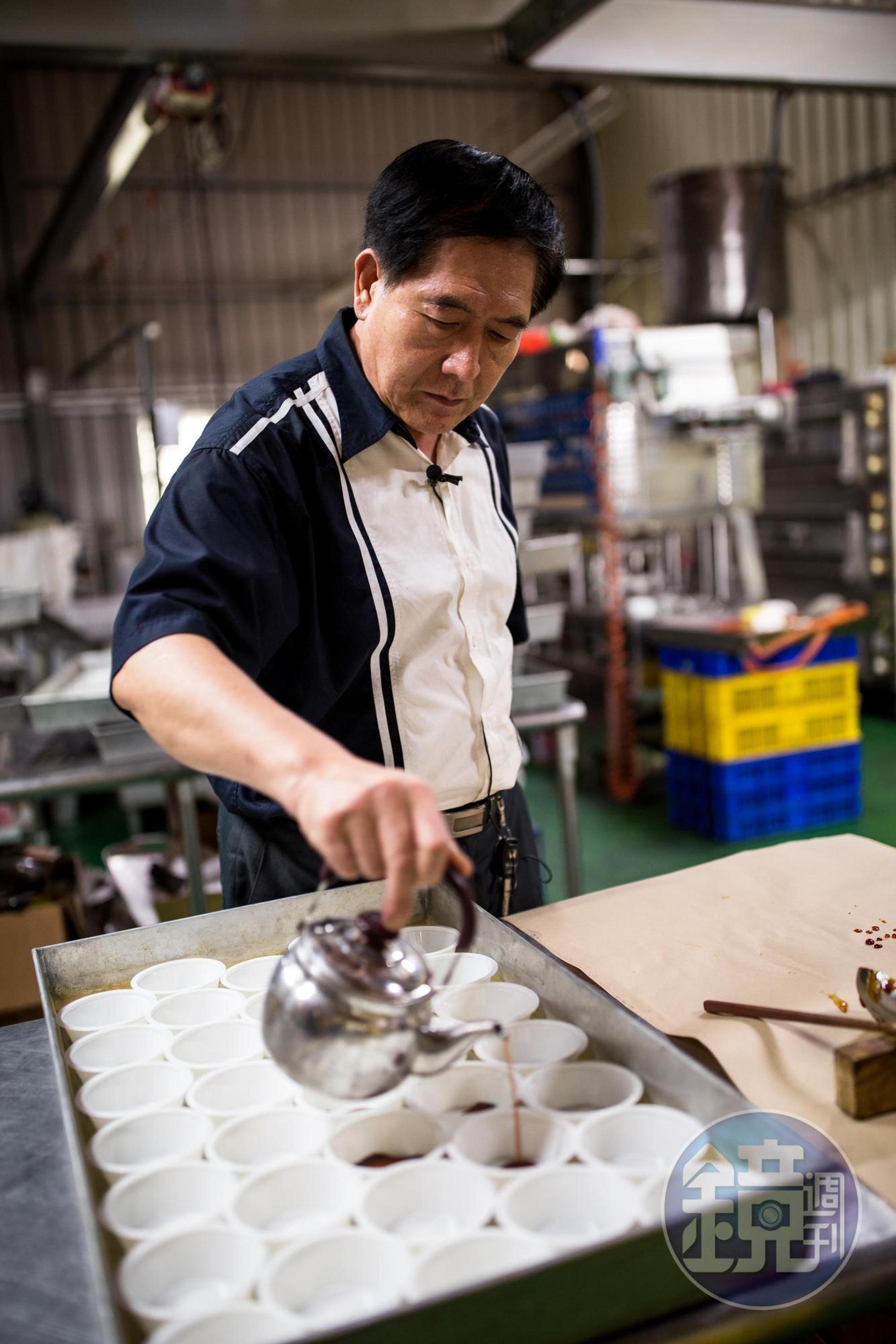 吳文耀拿著自製的銀色茶壺,準確地在布丁盒內內倒焦糖,長年下來,毋須使用磅秤,就能準確拿捏焦糖的份量。