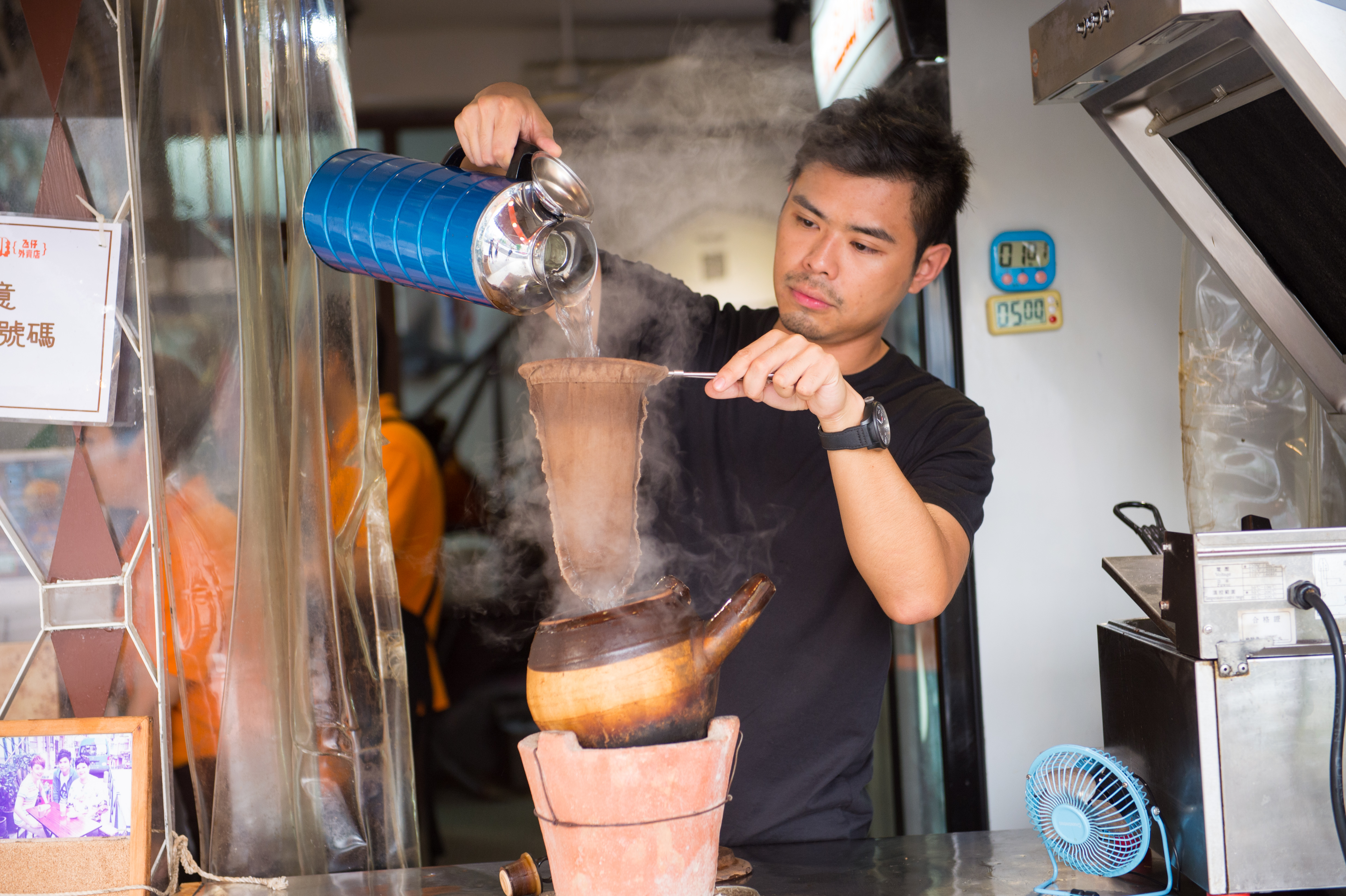 「世記咖啡」第3代主人Alvin拉起絲襪般濾布，來回冲2次滾水，咖啡香醇順口。