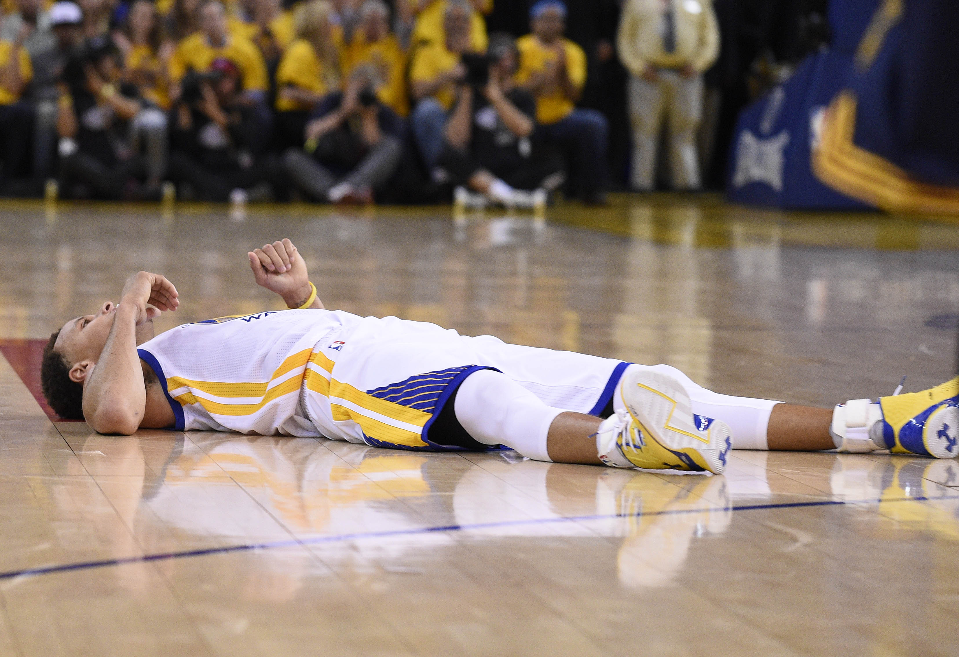 美國NBA季後冠軍決賽，金州勇士明星柯瑞攤平躺在球場上。（東方IC）