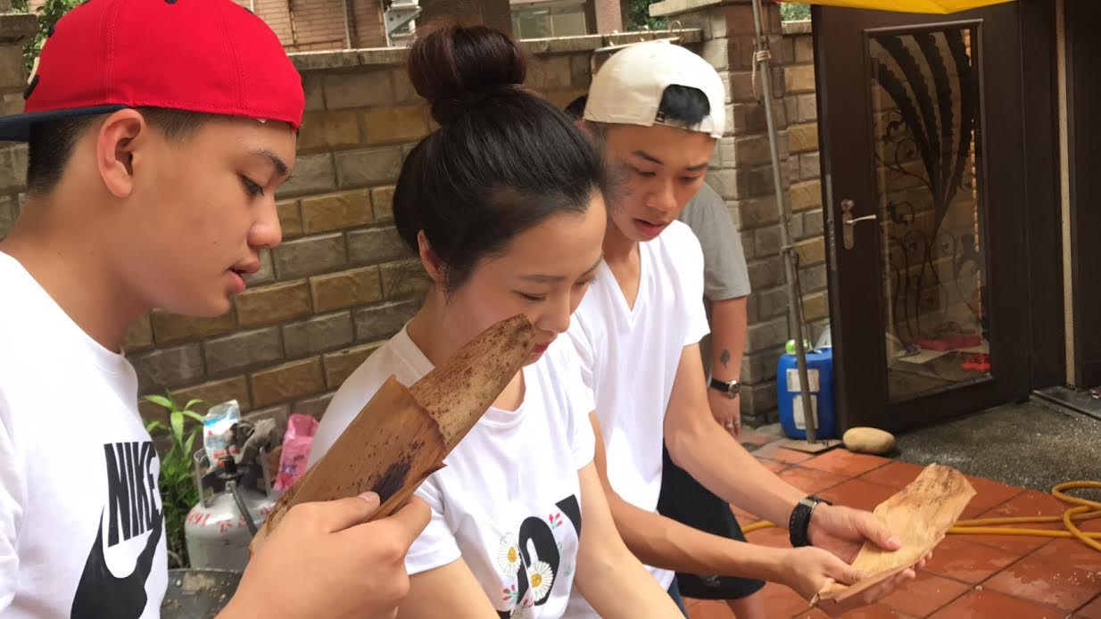 吳政迪(右)跟趙小僑學習怎麼包粽子。(修毅提供)