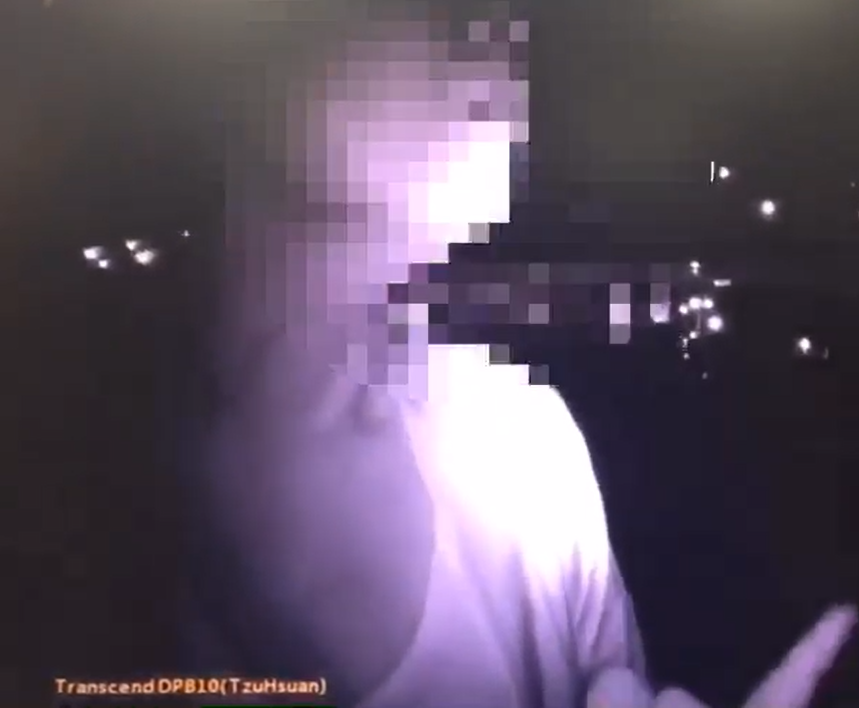 射箭教練陳伯謙的羅姓女友人向警方比出中指，遭警方以妨礙公務送辦。（警方提供）