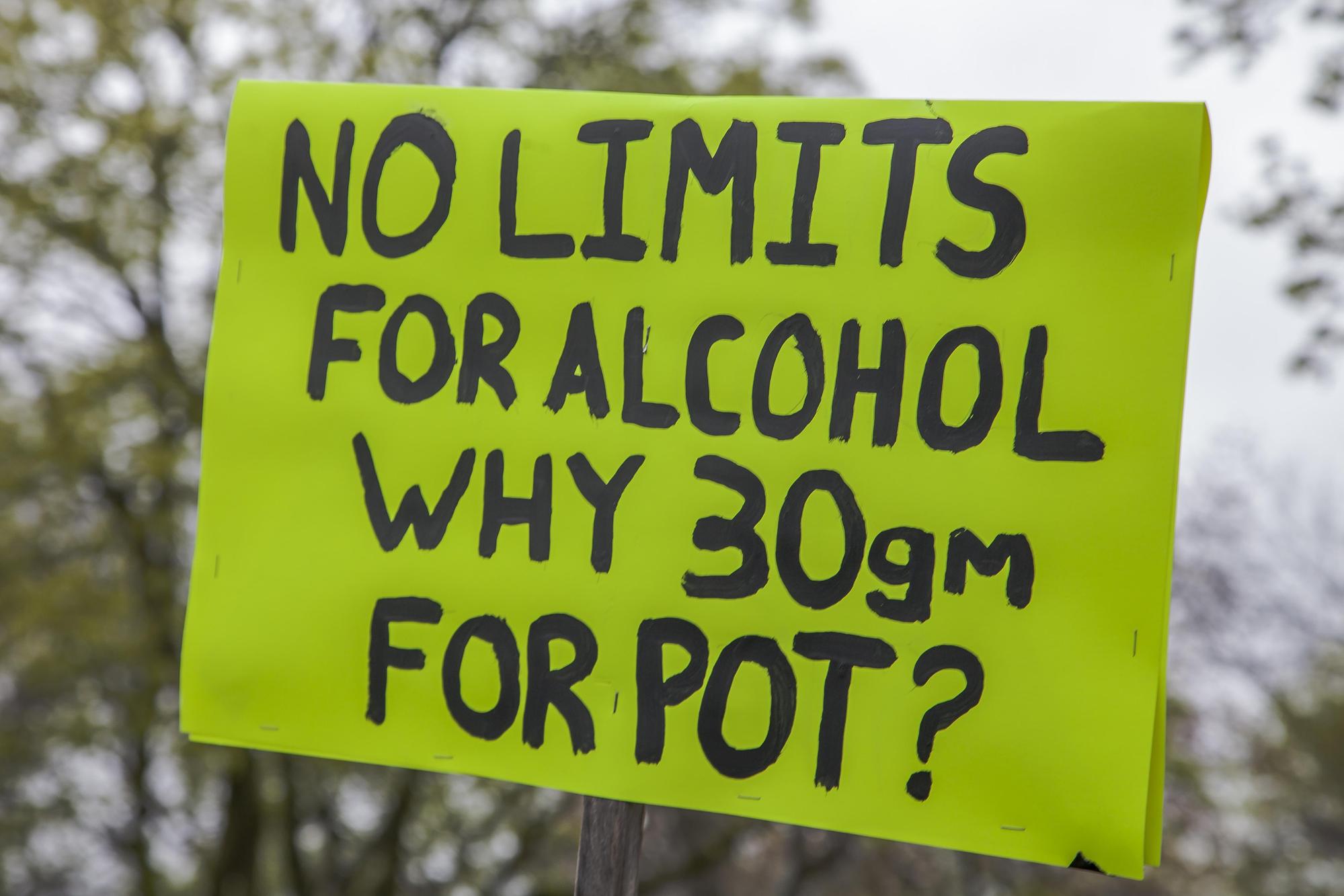 支持大麻合法的遊行民眾中,有人舉著標語質問:「酒精沒設限,為什麼30克的大麻(犯法)?」(東方IC)